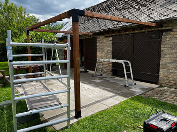 Patio area with wooden pergola structure and ladders on a patio