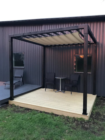 Patio with pergola, table, and chairs in front of a building