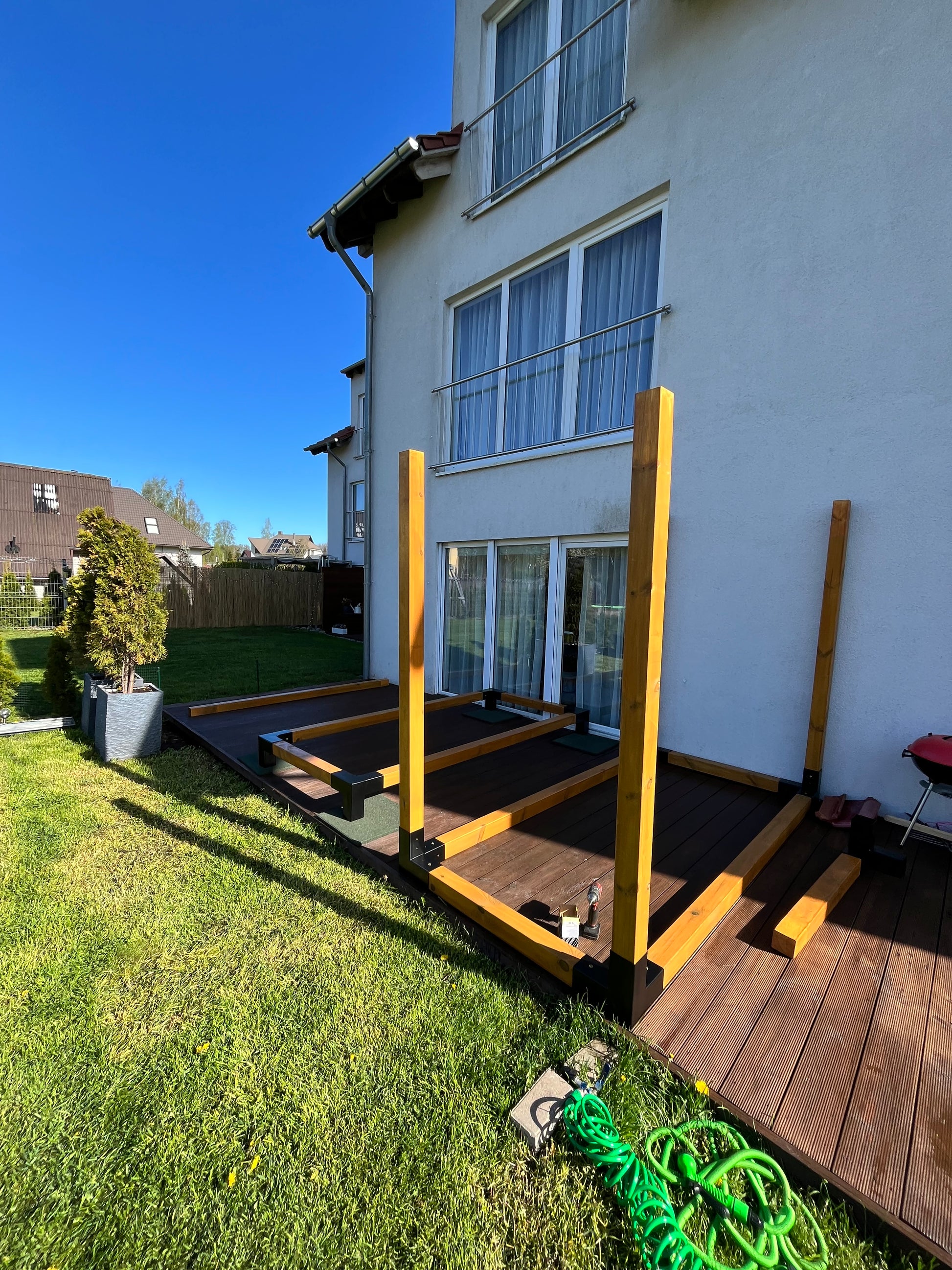 Wooden deck extension on a house with a clear blue sky
