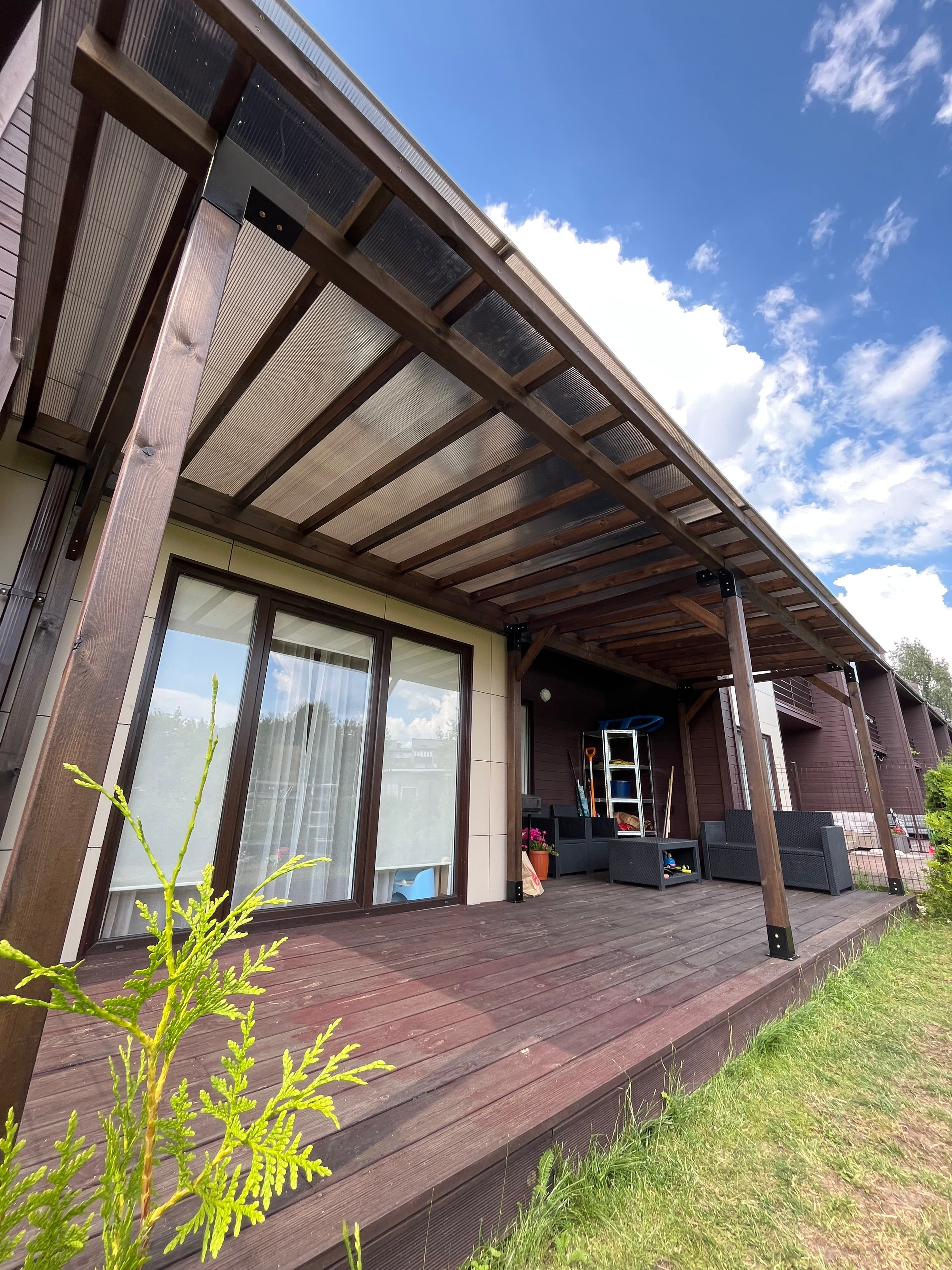 Wooden exterior of a building with glass windows and a clear blue sky.