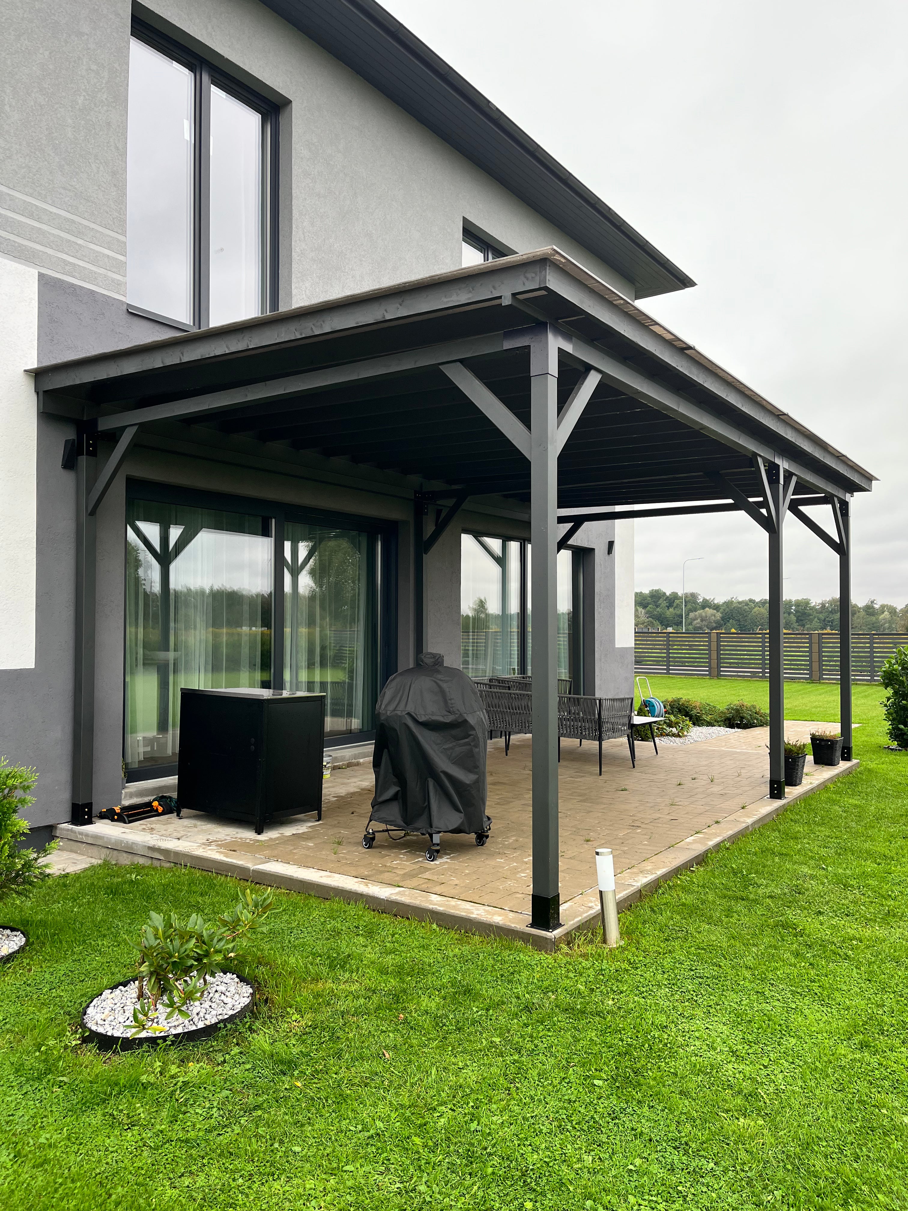 Patio cover attached to a modern house with outdoor furniture and pergola