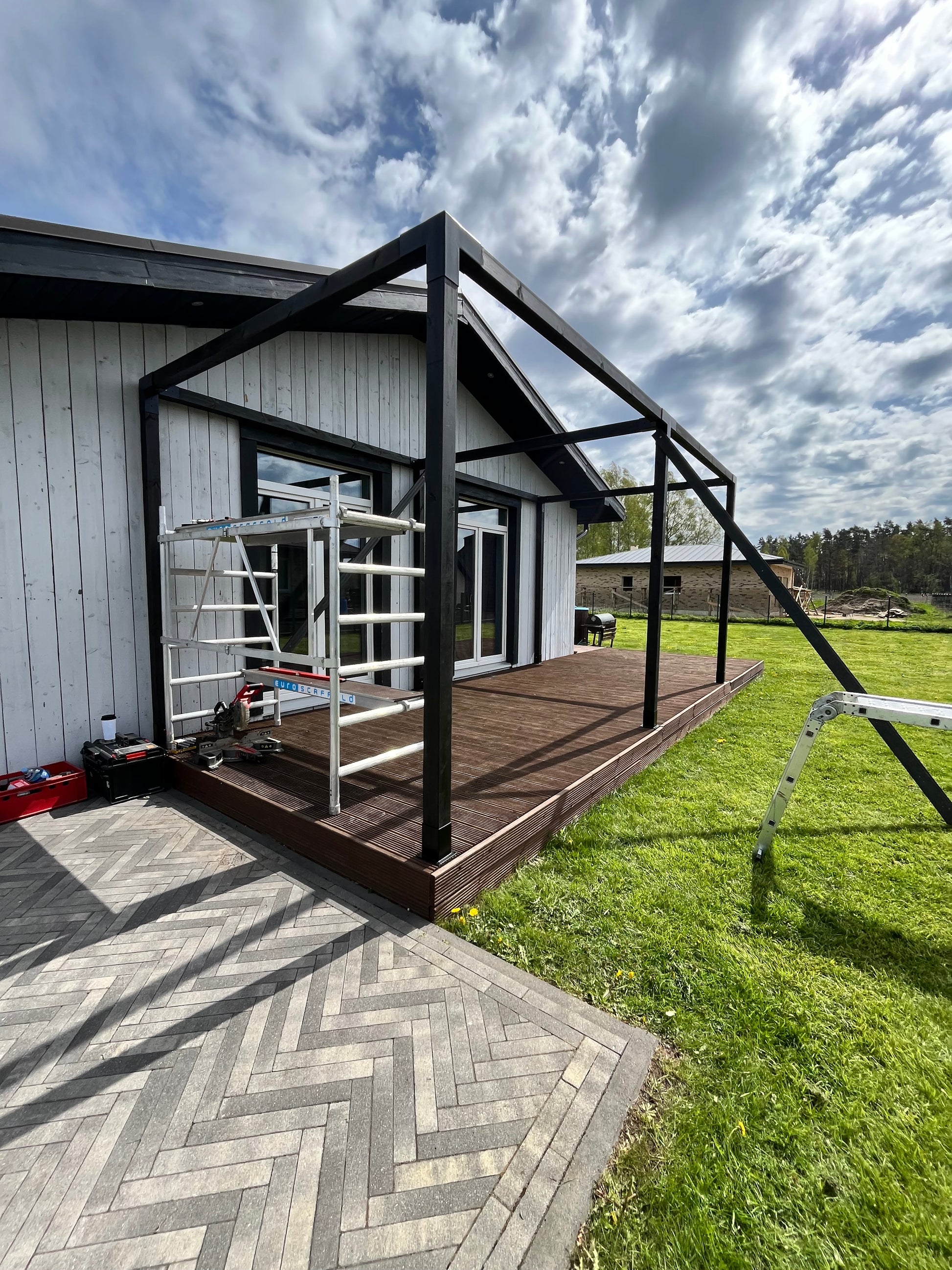 Fire escape ladder on a building with grass and sky in the background