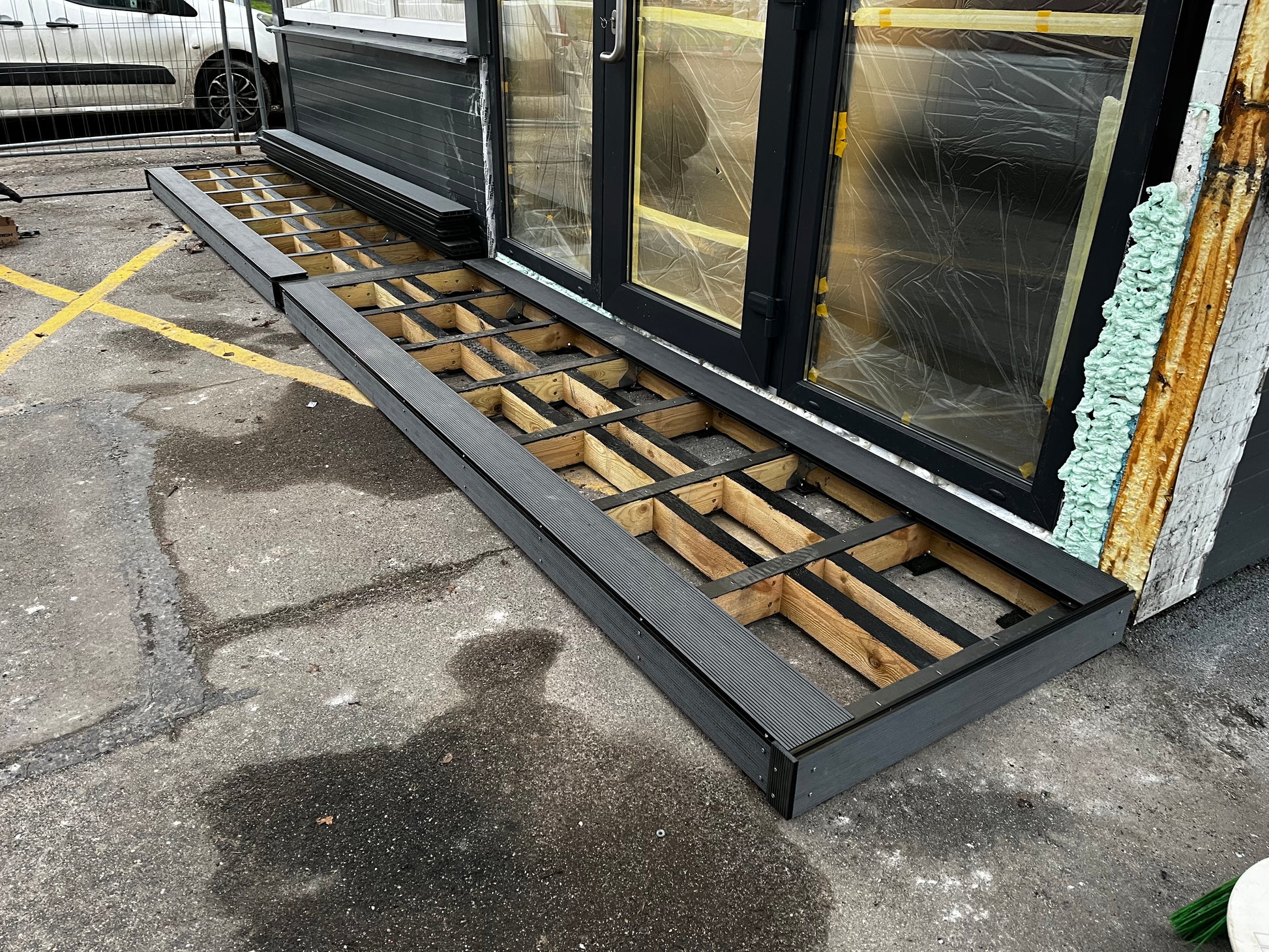 Window frame assembly on a concrete floor with visible construction materials.