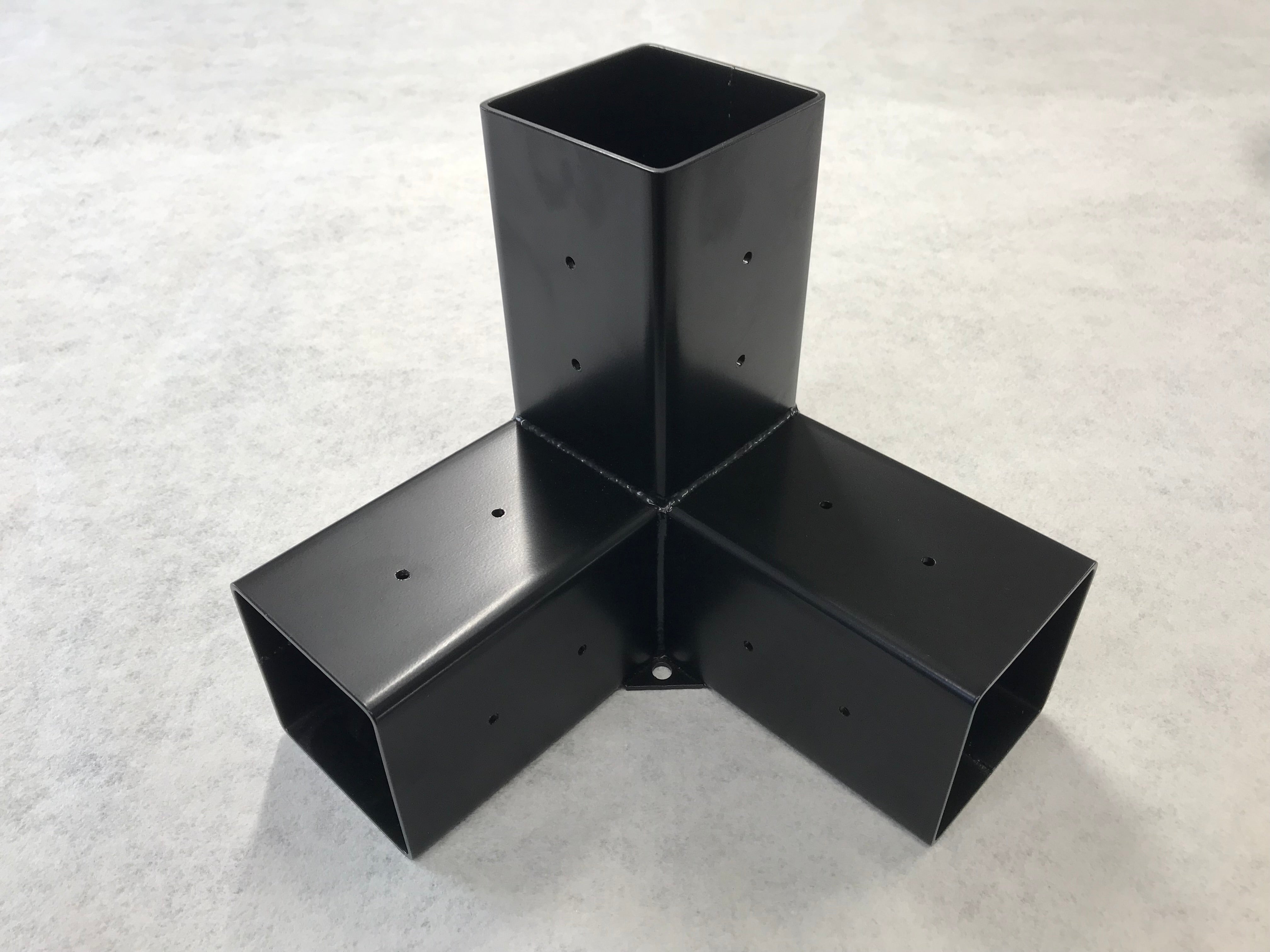 Black metal corner bracket on a light gray background