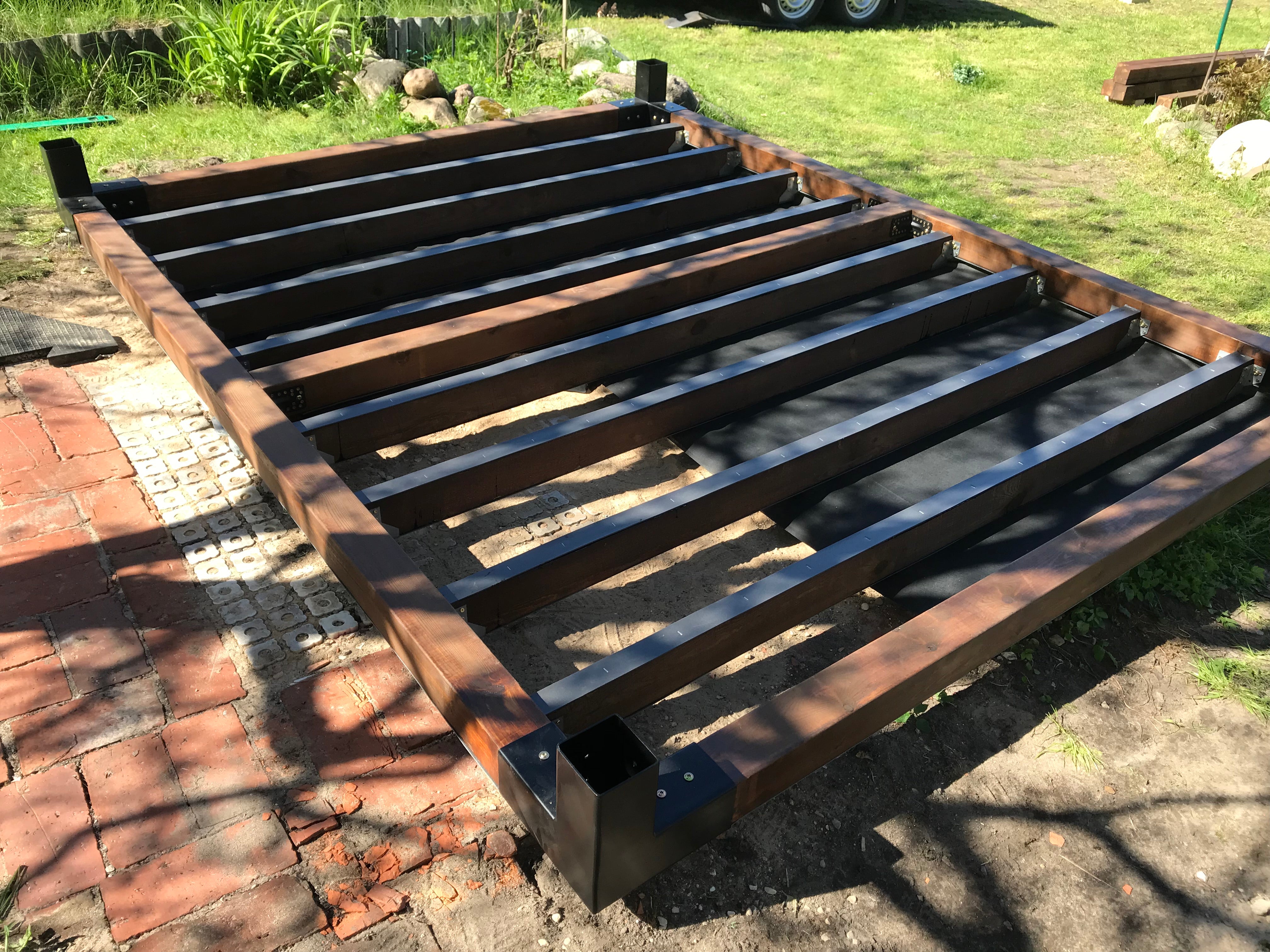 Metal pallet on a brick surface with grass and a vehicle in the background