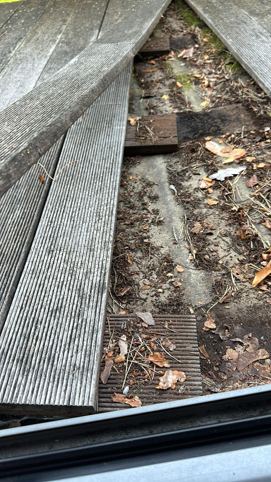 Wooden deck with a gap leading to a dirt area