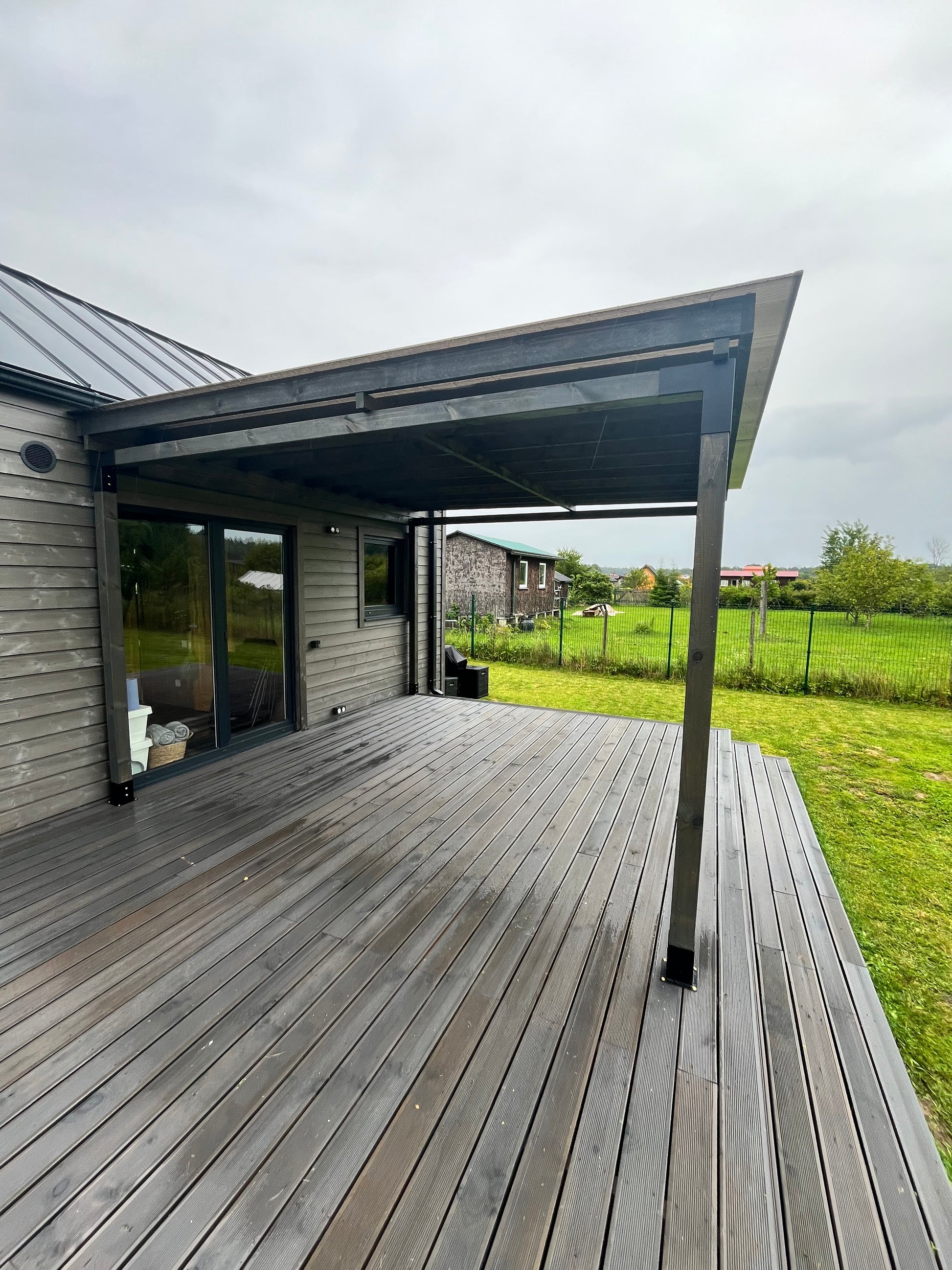 Modern house exterior with glass doors and wooden deck