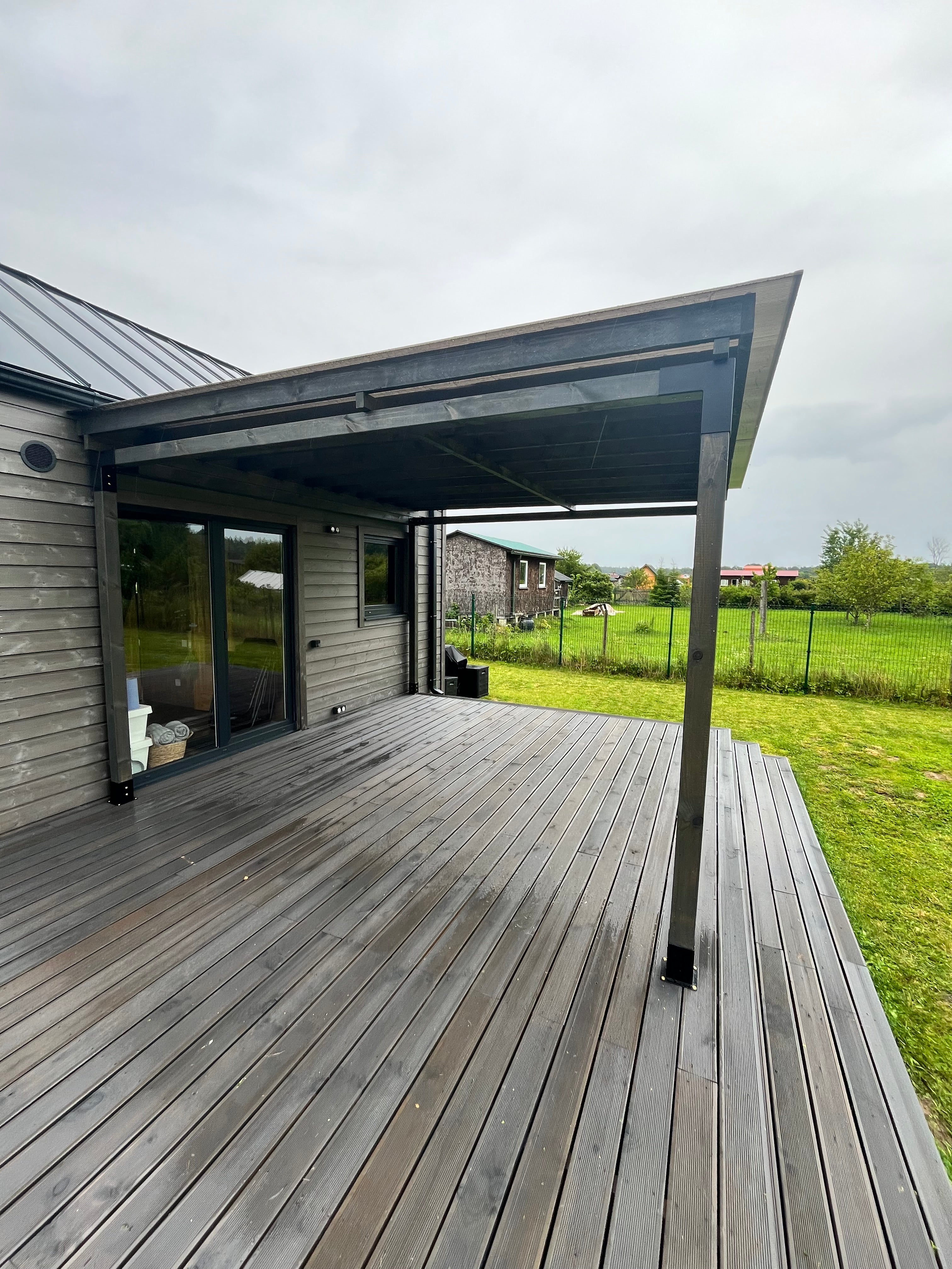 Modern house exterior with glass doors and wooden deck