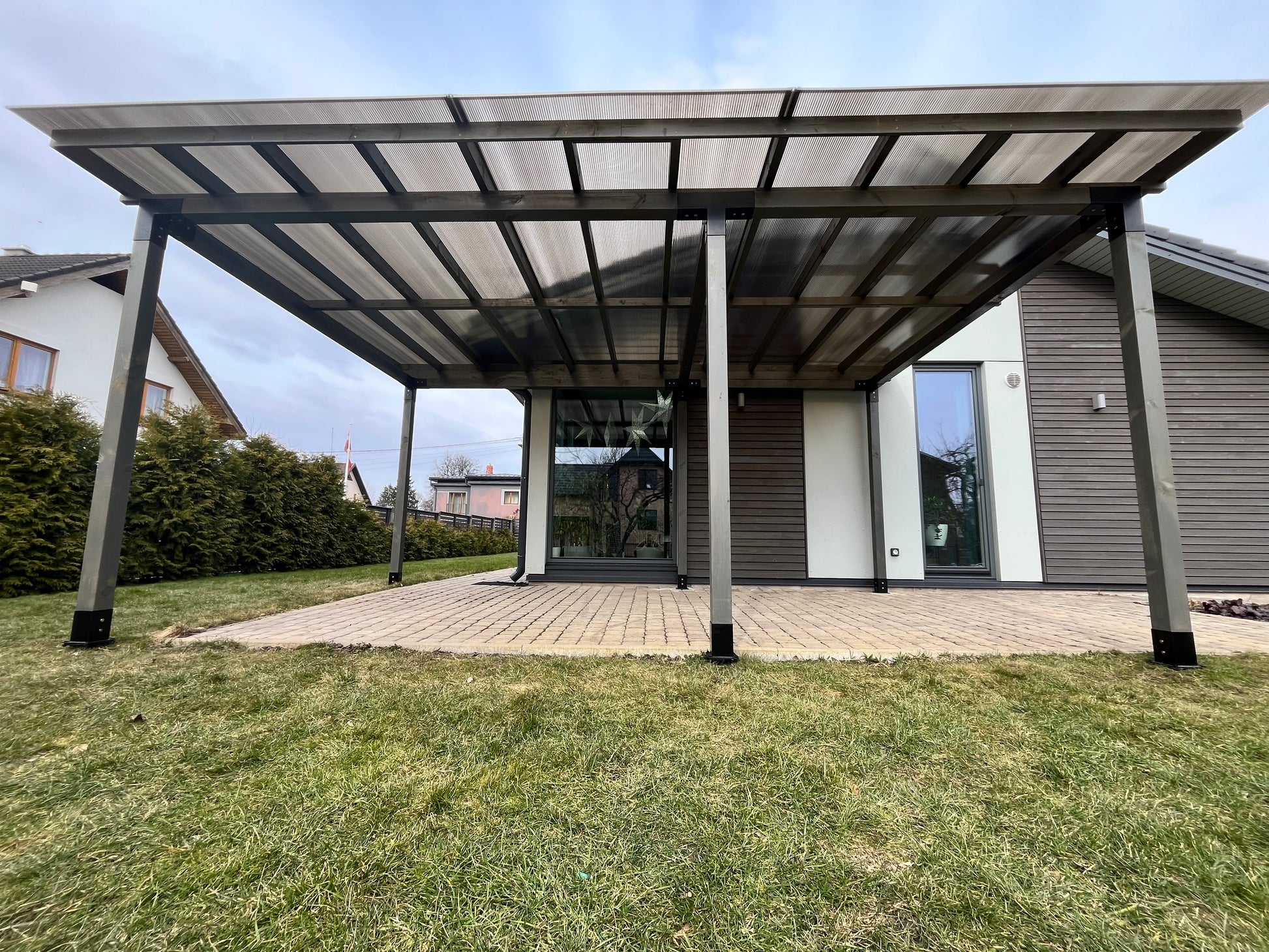 Modern carport attached to a house with a clear sky background