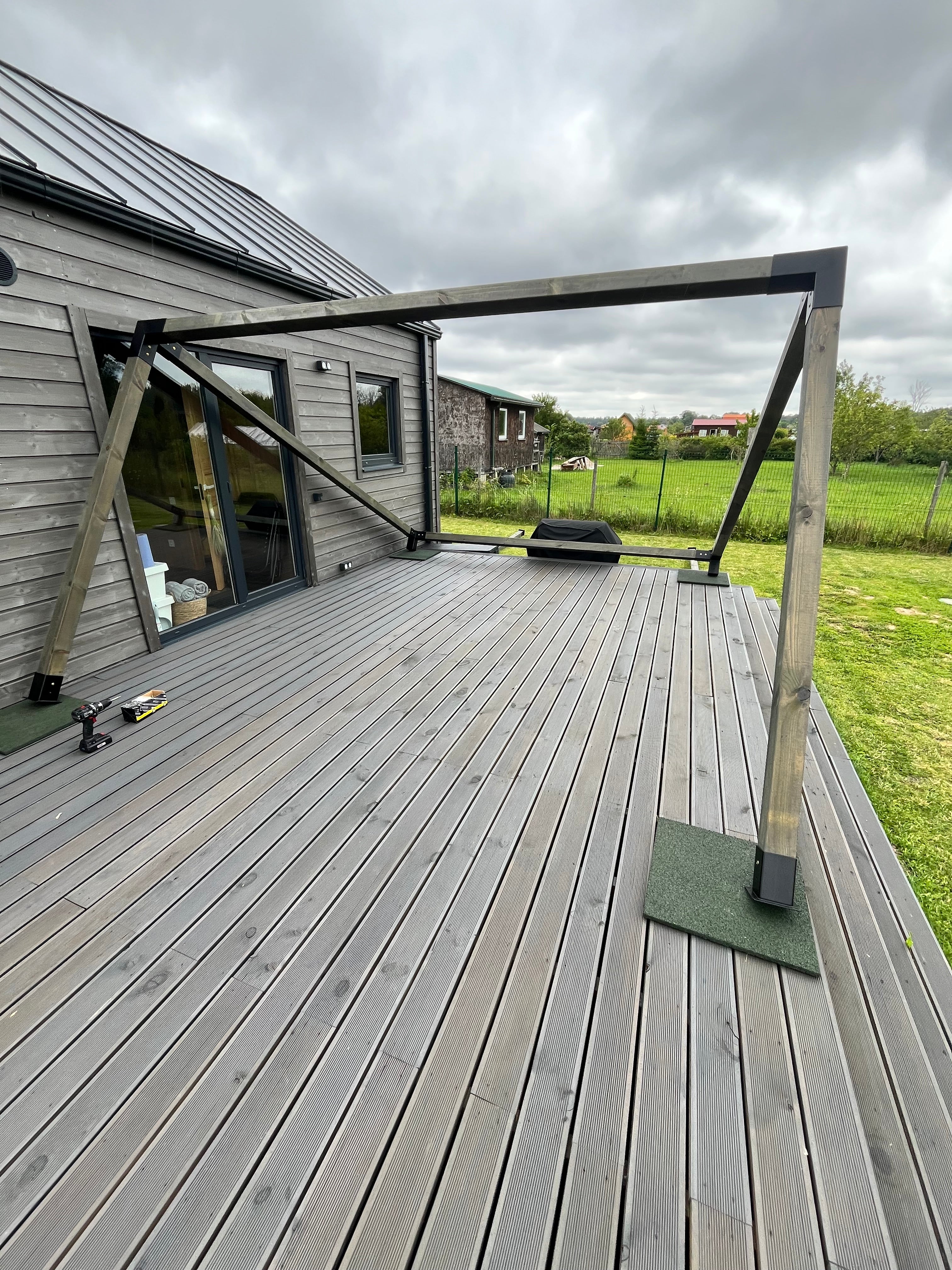 Wooden deck with glass balustrade overlooking a green landscape
