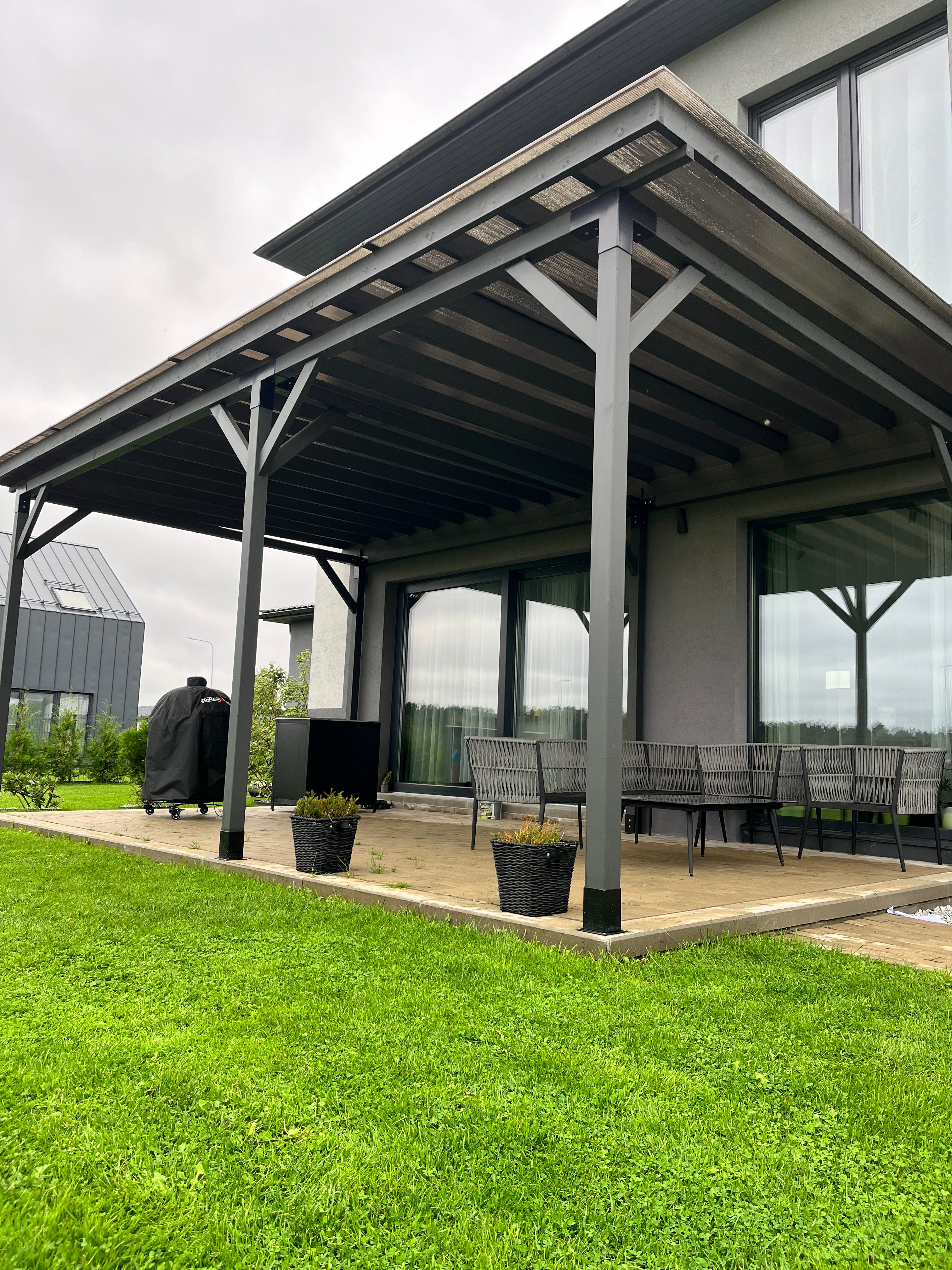 Patio area with a covered outdoor living space, lawn, and garden.
