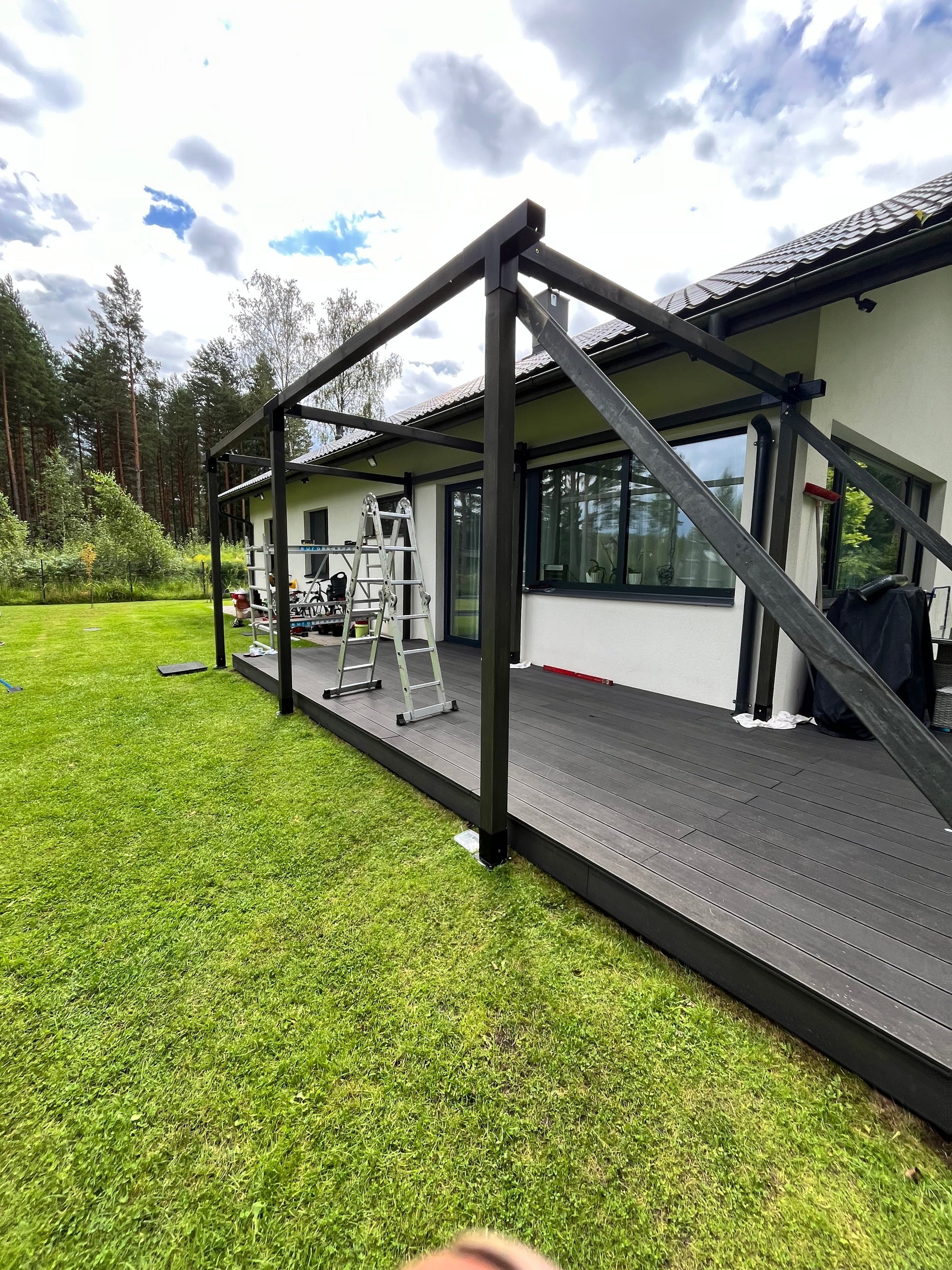Patio cover with grass and sky in the background