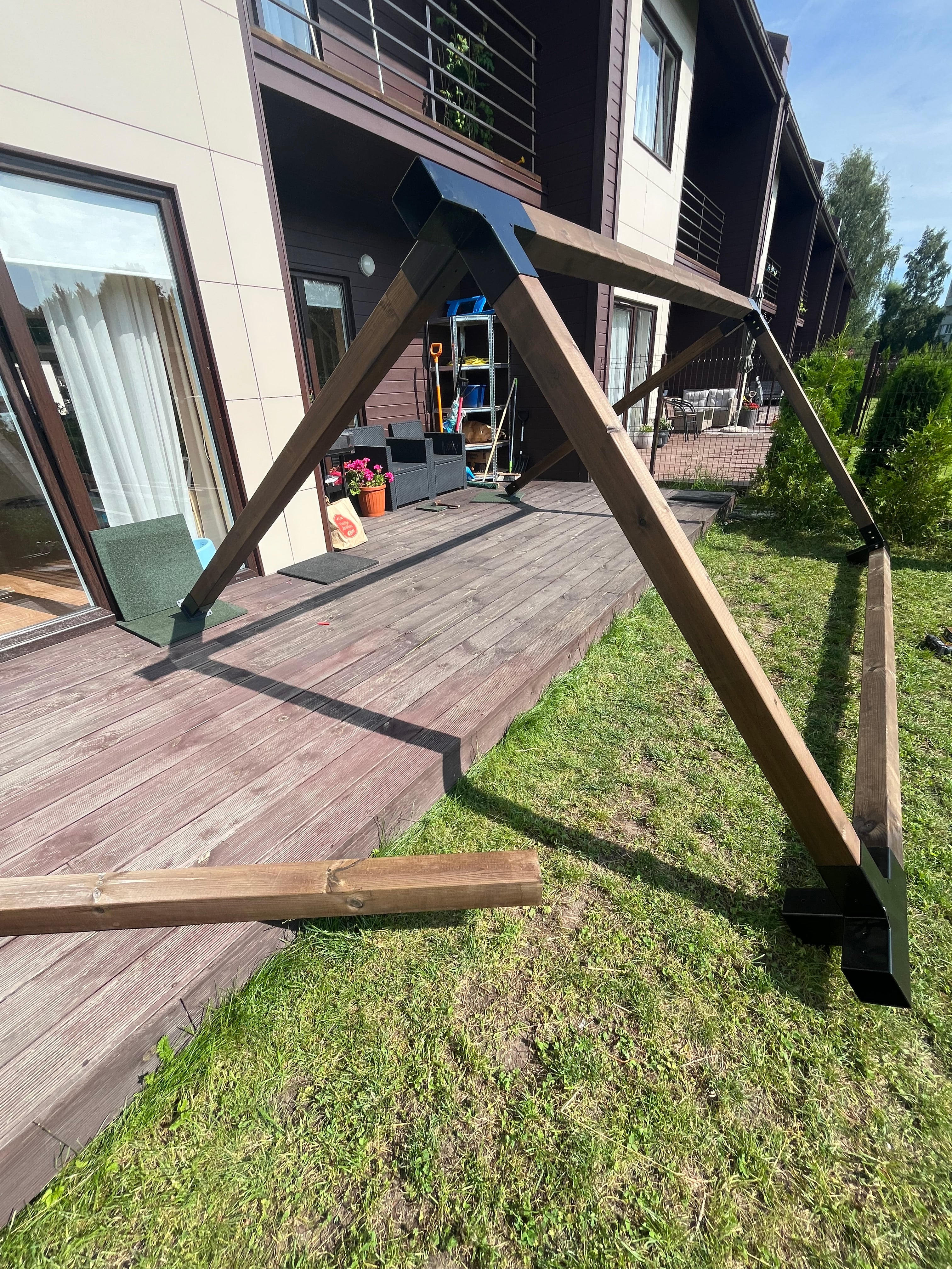 Wooden deck with a railing overlooking a house and garden