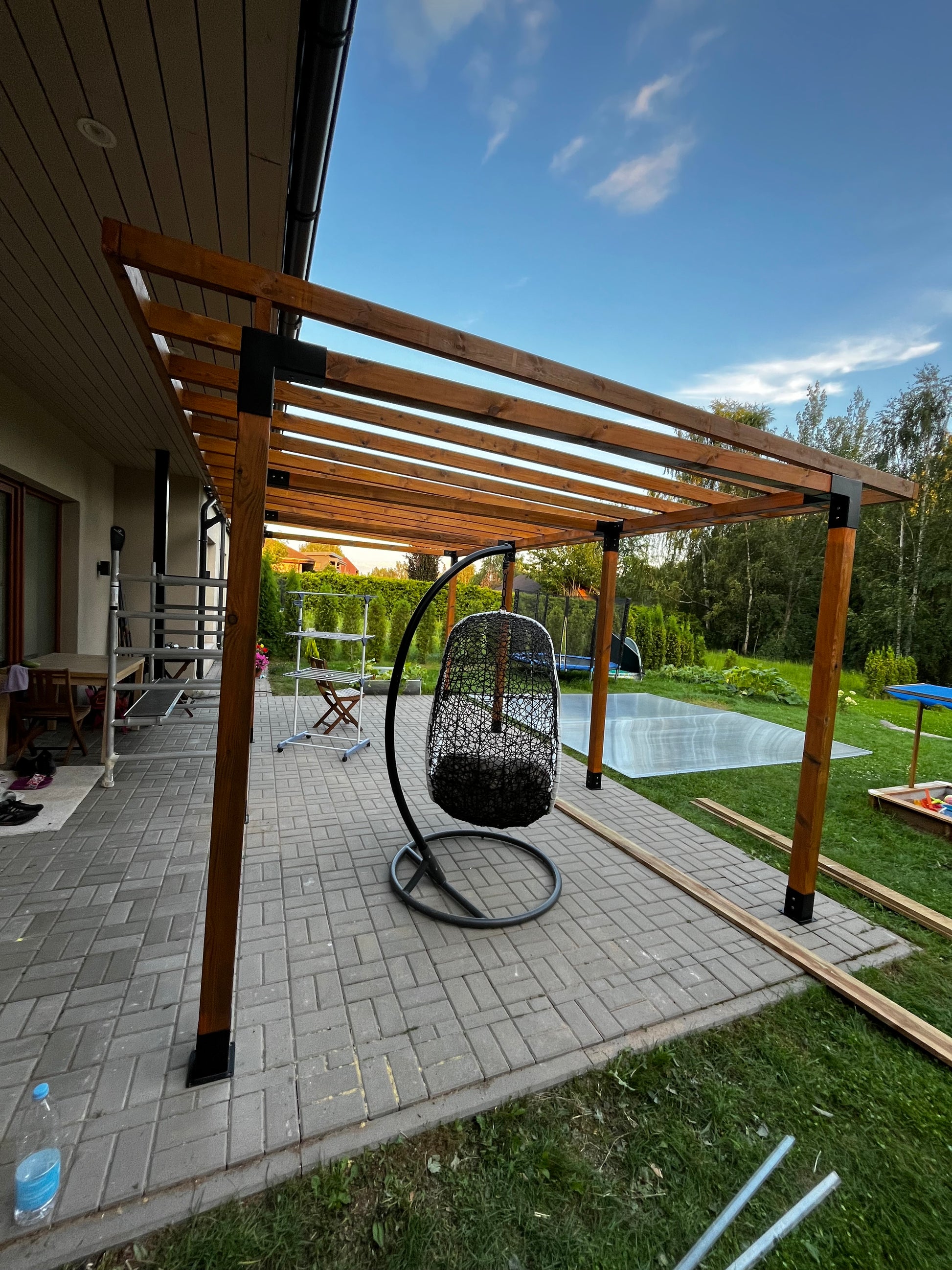 Wooden staircase leading to a roof with a chair on the steps, outdoors.