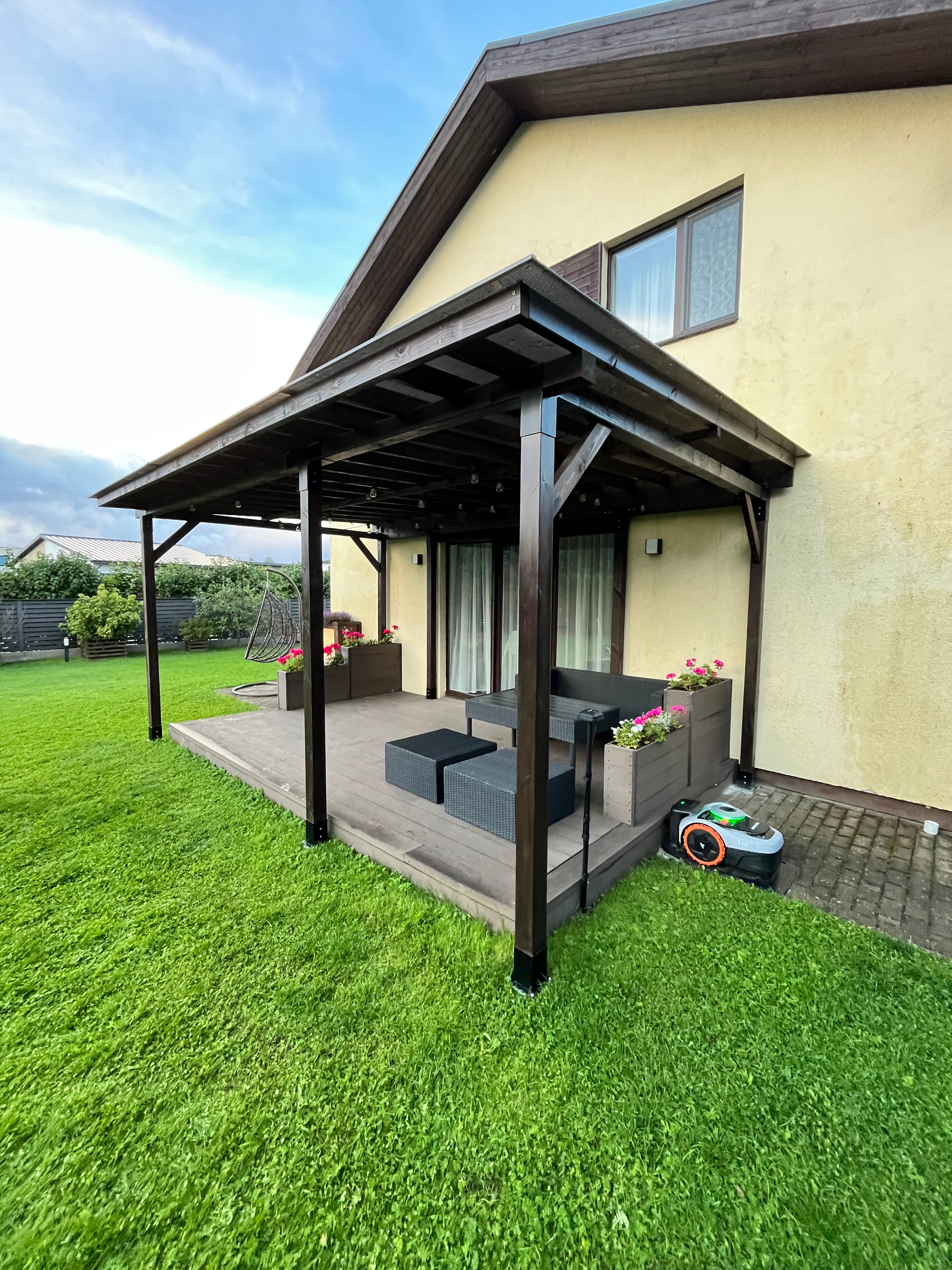 Balcony with canopy and outdoor furniture on a grassy area