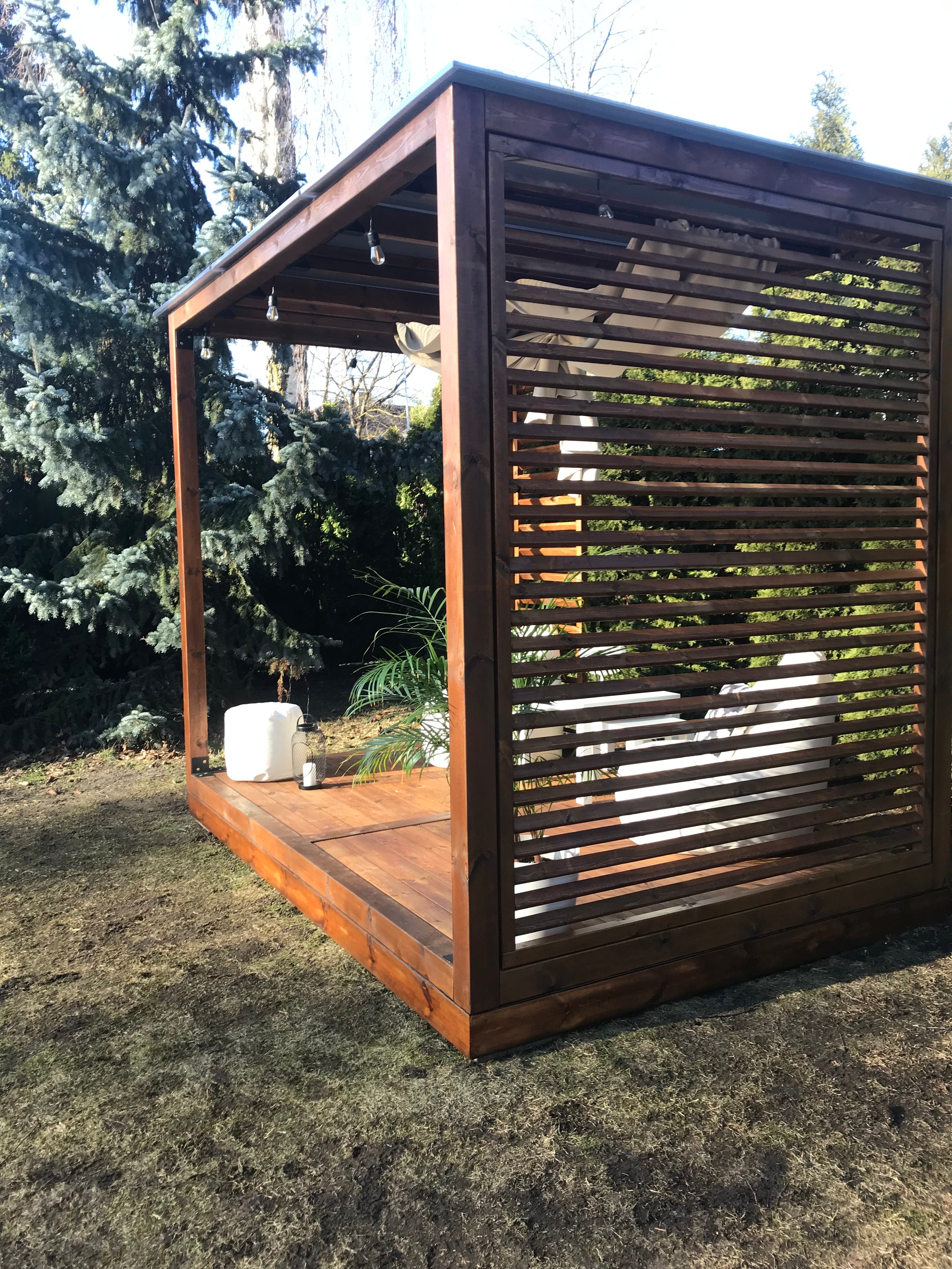 Wooden outdoor grill with metal grate on a grassy area