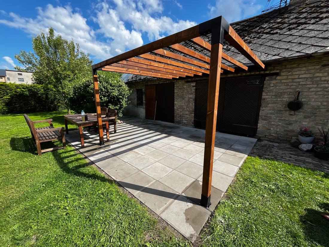 Wooden pergola in a backyard with grass and a clear sky