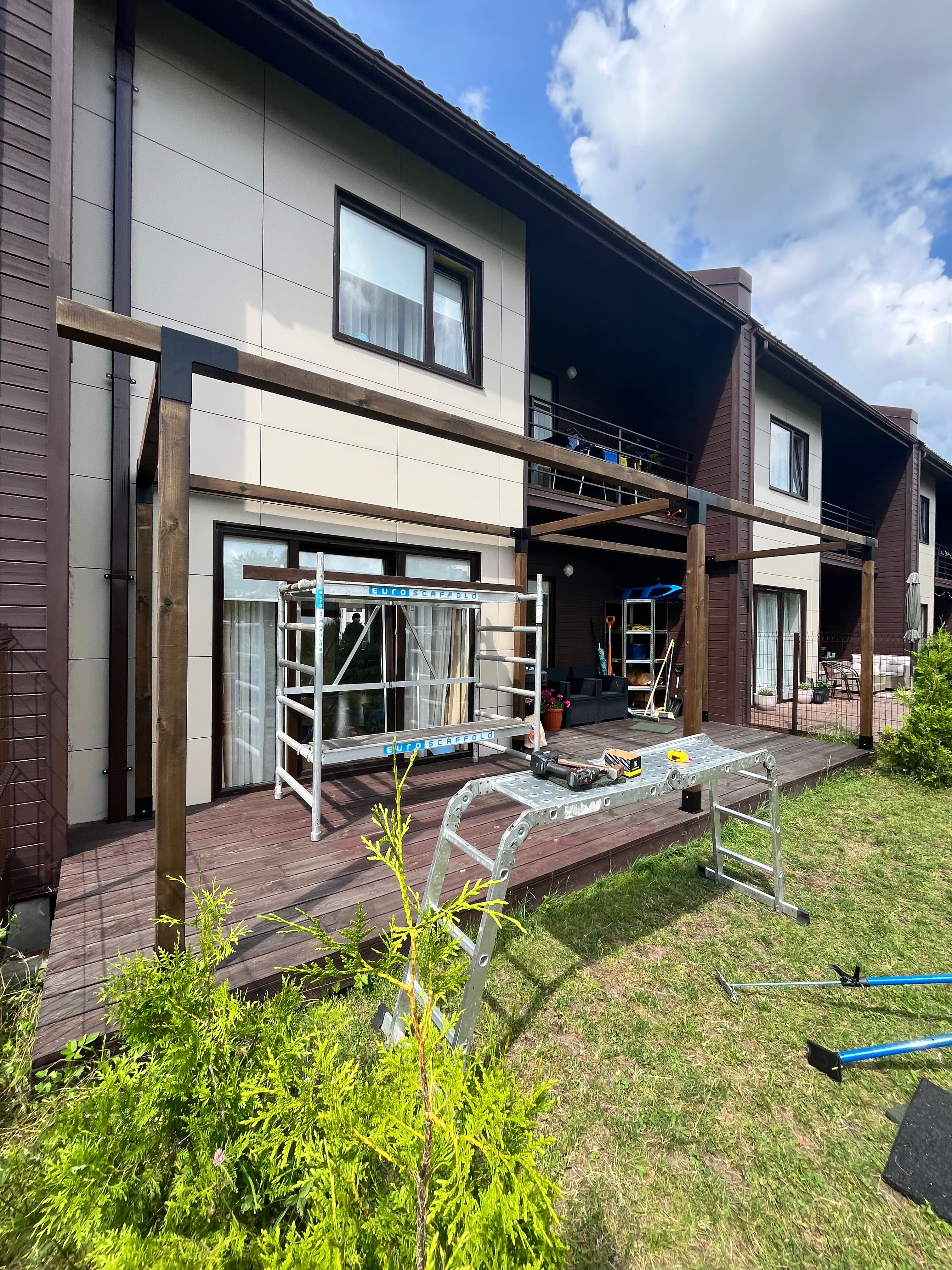 Two-story house with a deck and outdoor furniture on a sunny day.