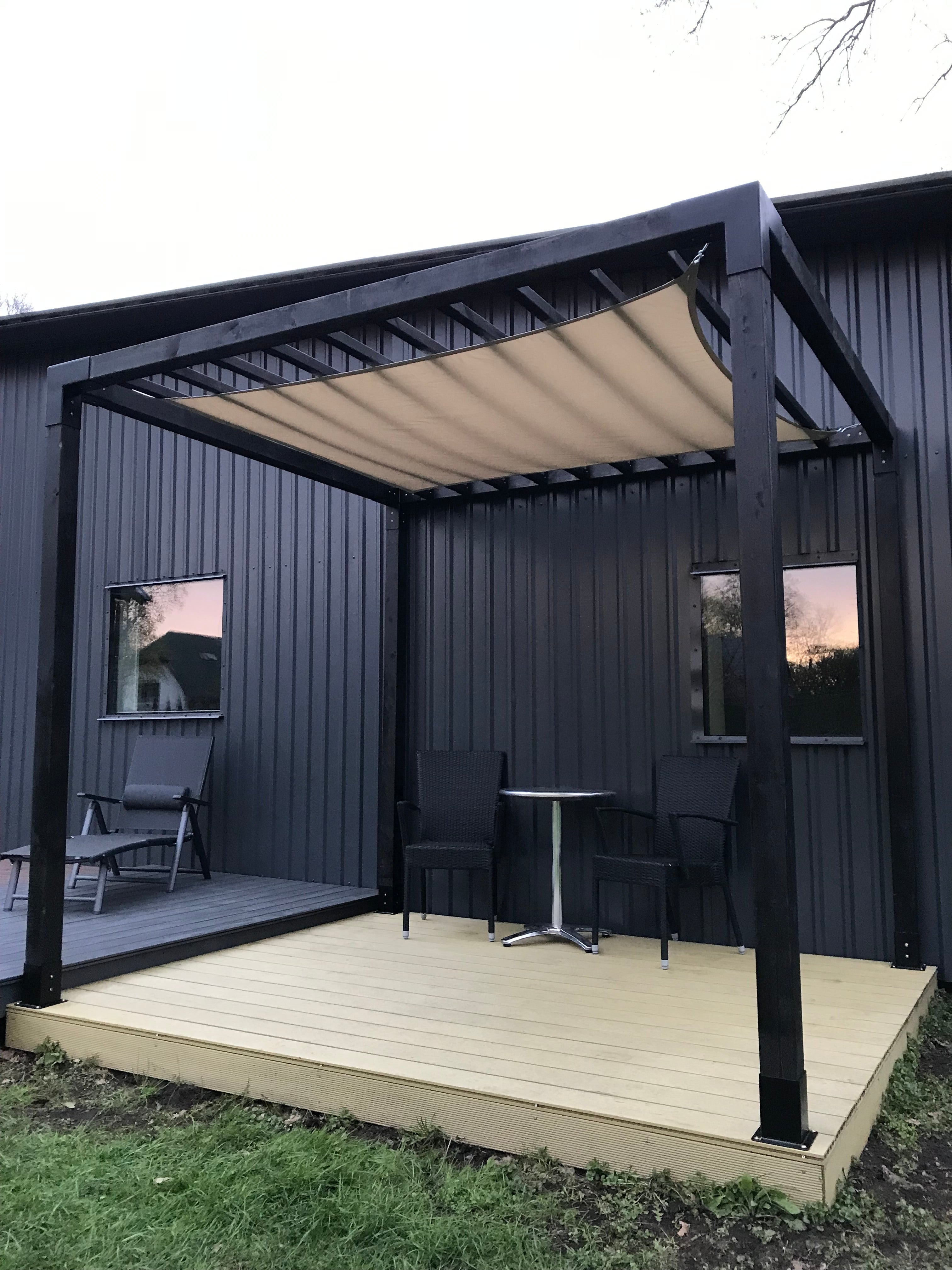 Top-down view of a modern house exterior with a deck and outdoor furniture.