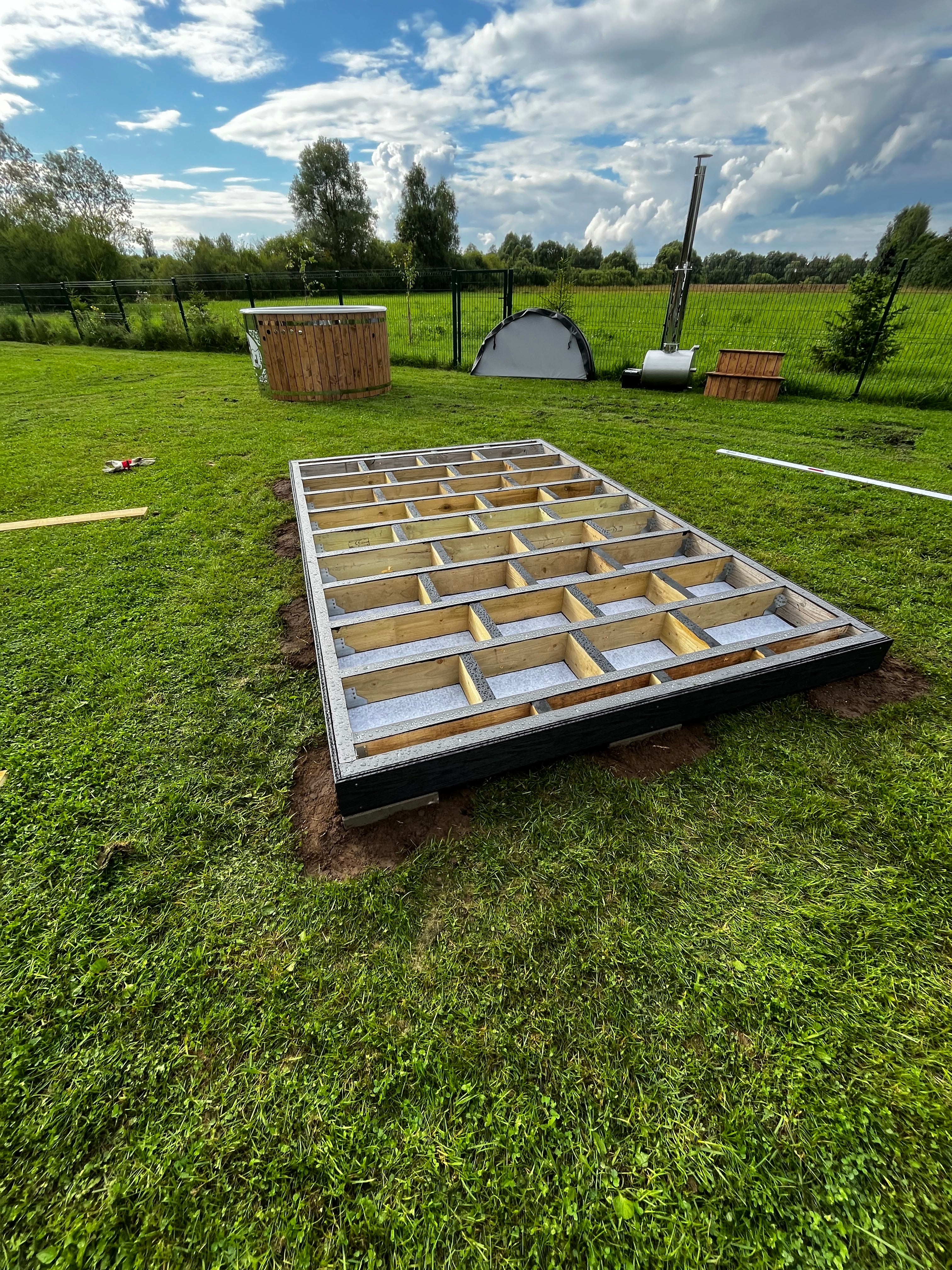 Large rectangular object with a grid pattern on grass under a blue sky
