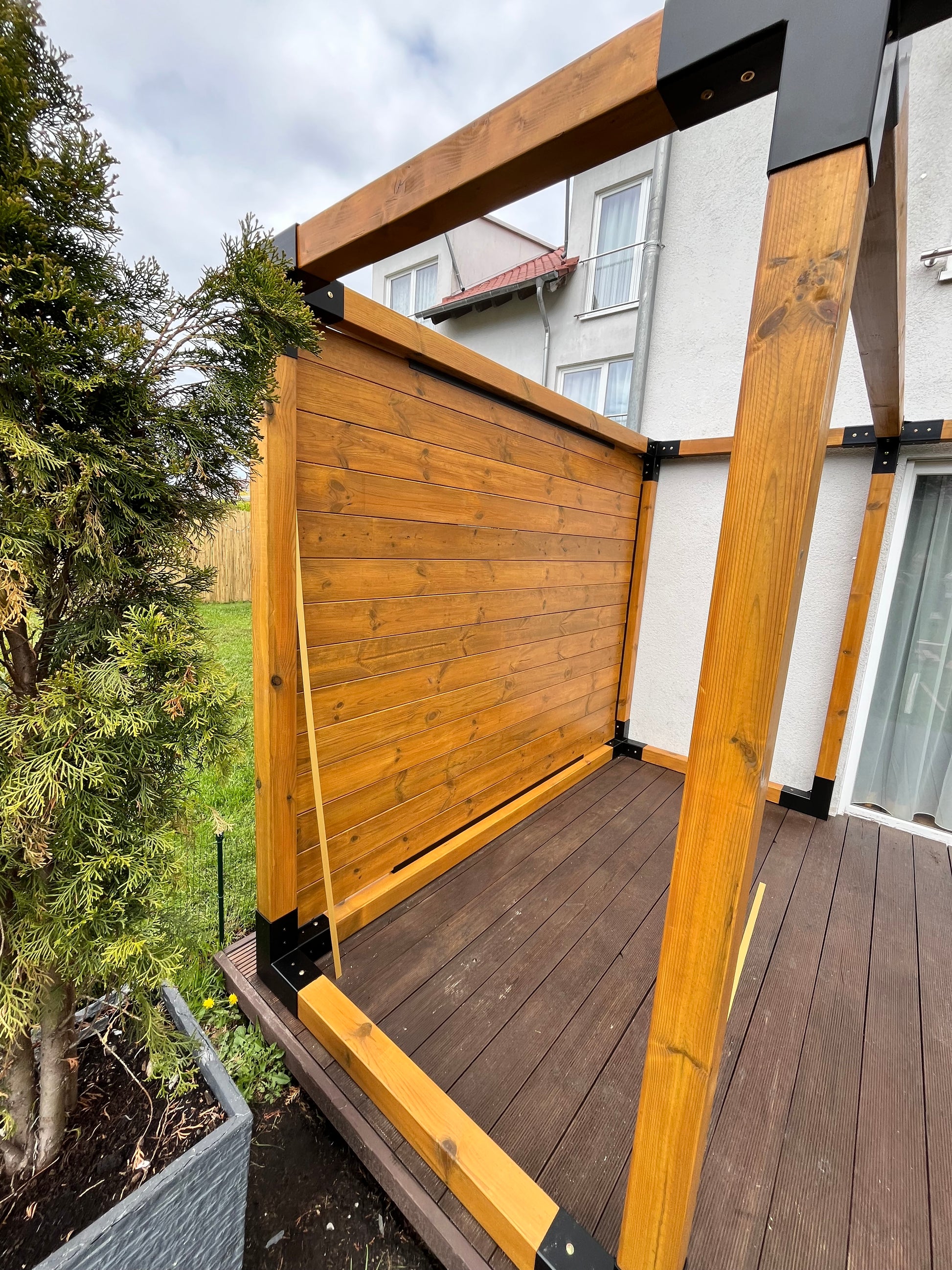 Wooden deck extension attached to a house with greenery in the foreground