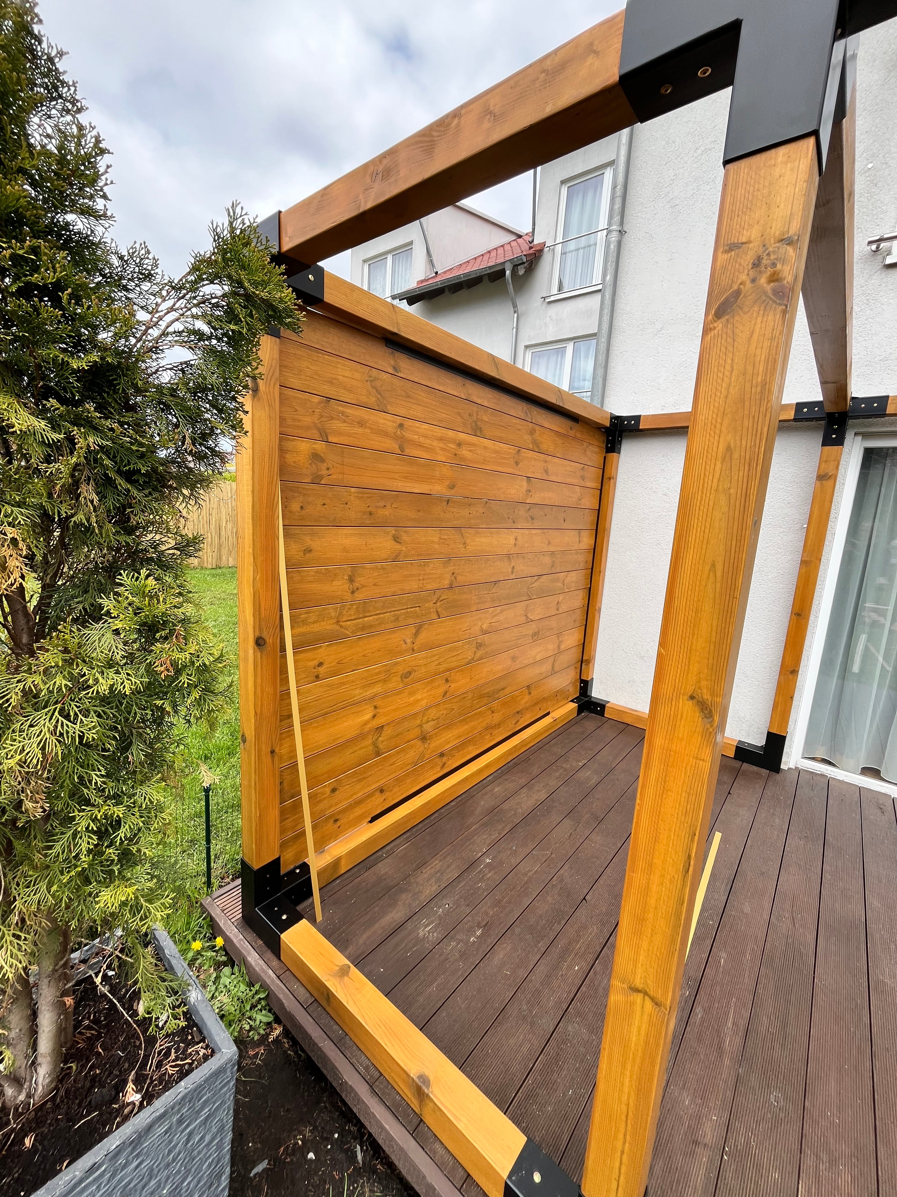 Wooden deck extension attached to a house with greenery in the foreground