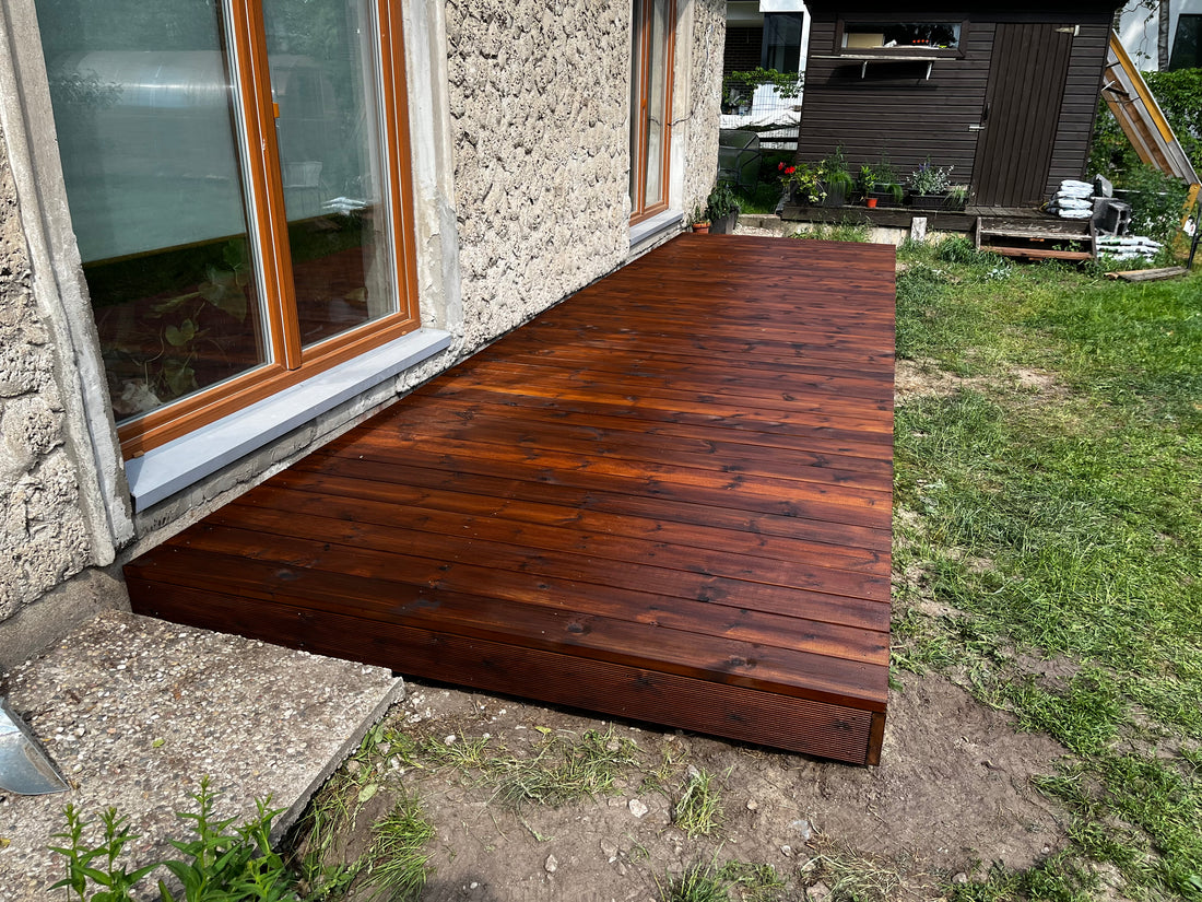 Wooden deck extension attached to a house with stone exterior