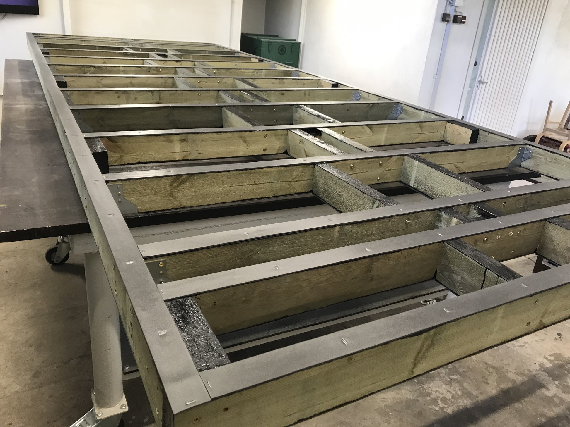 Wooden frame structure on a concrete floor with metal brackets