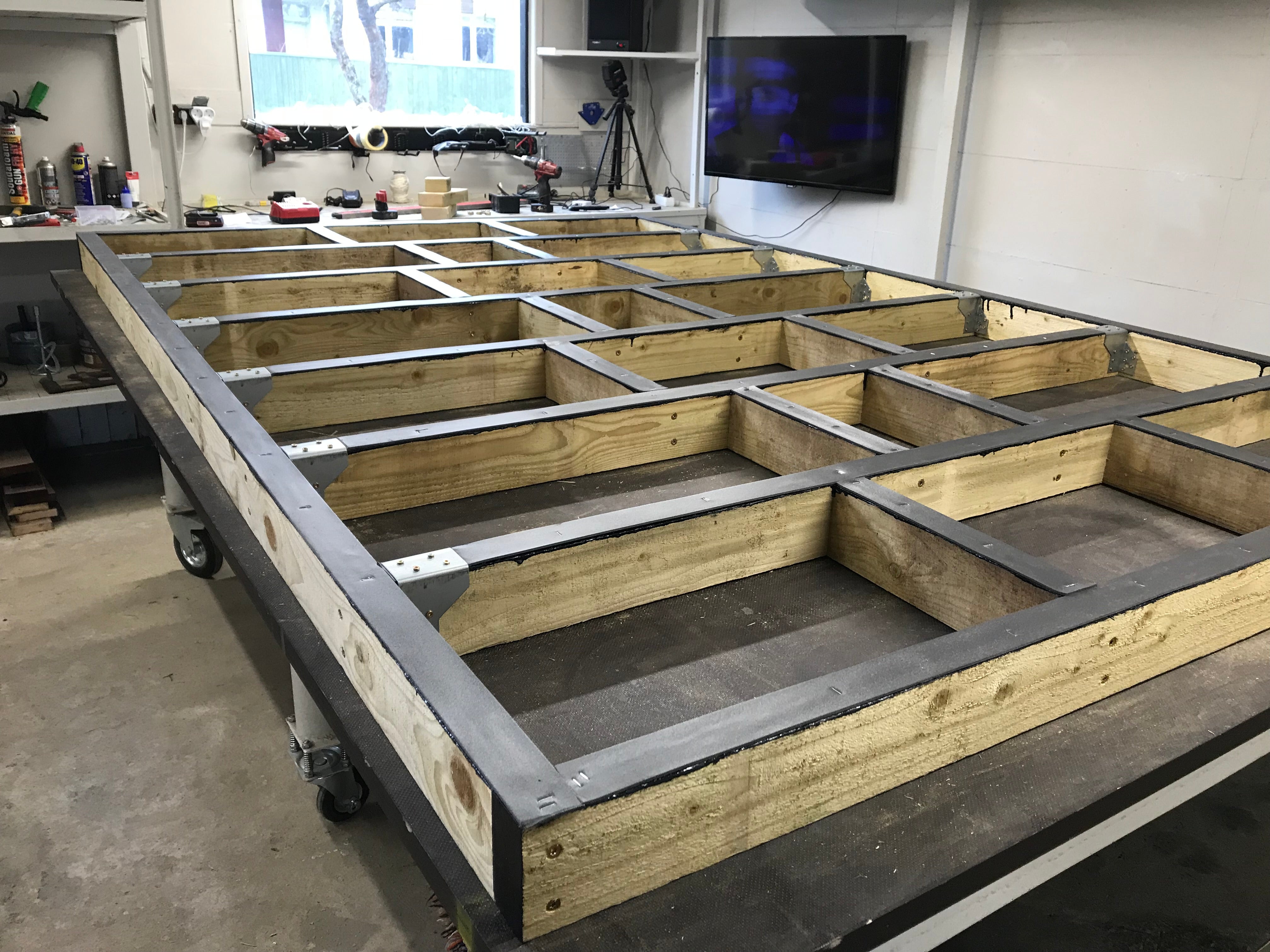 Wooden floor structure on wheels in a workshop setting