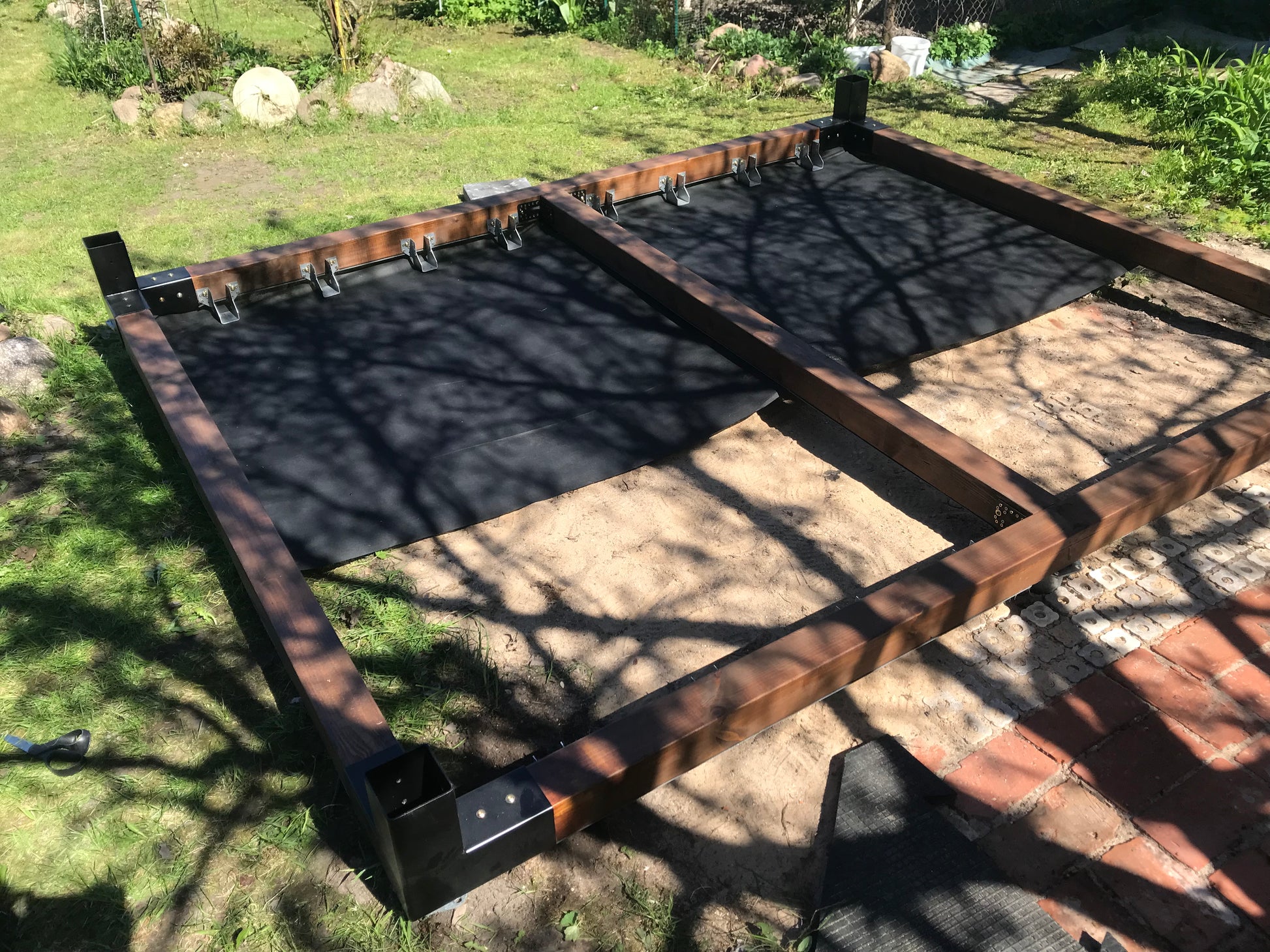 Metal frame on a grassy area with shadows cast by trees