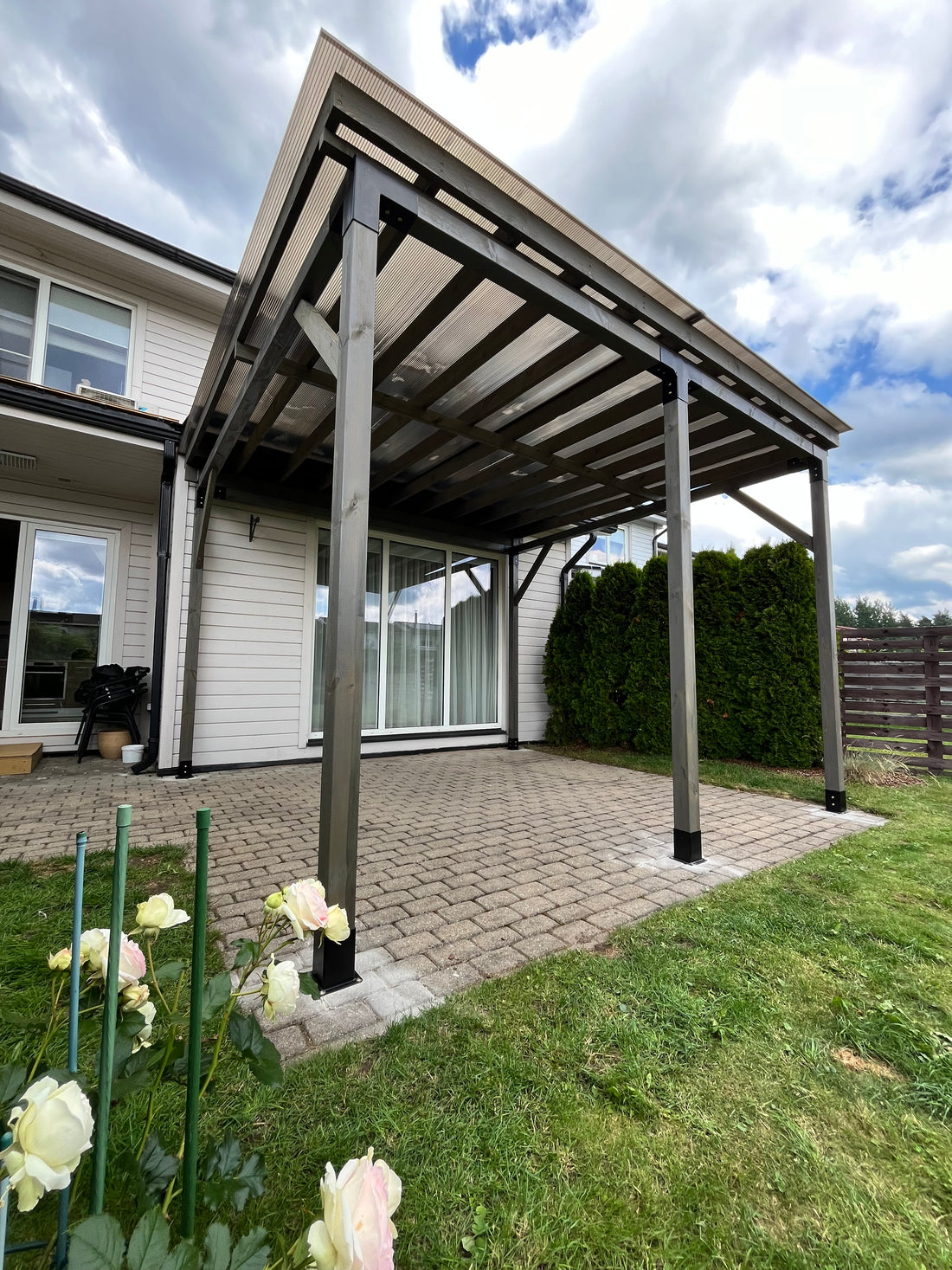 Outdoor patio table with chairs on a patio area with flowers in the foreground