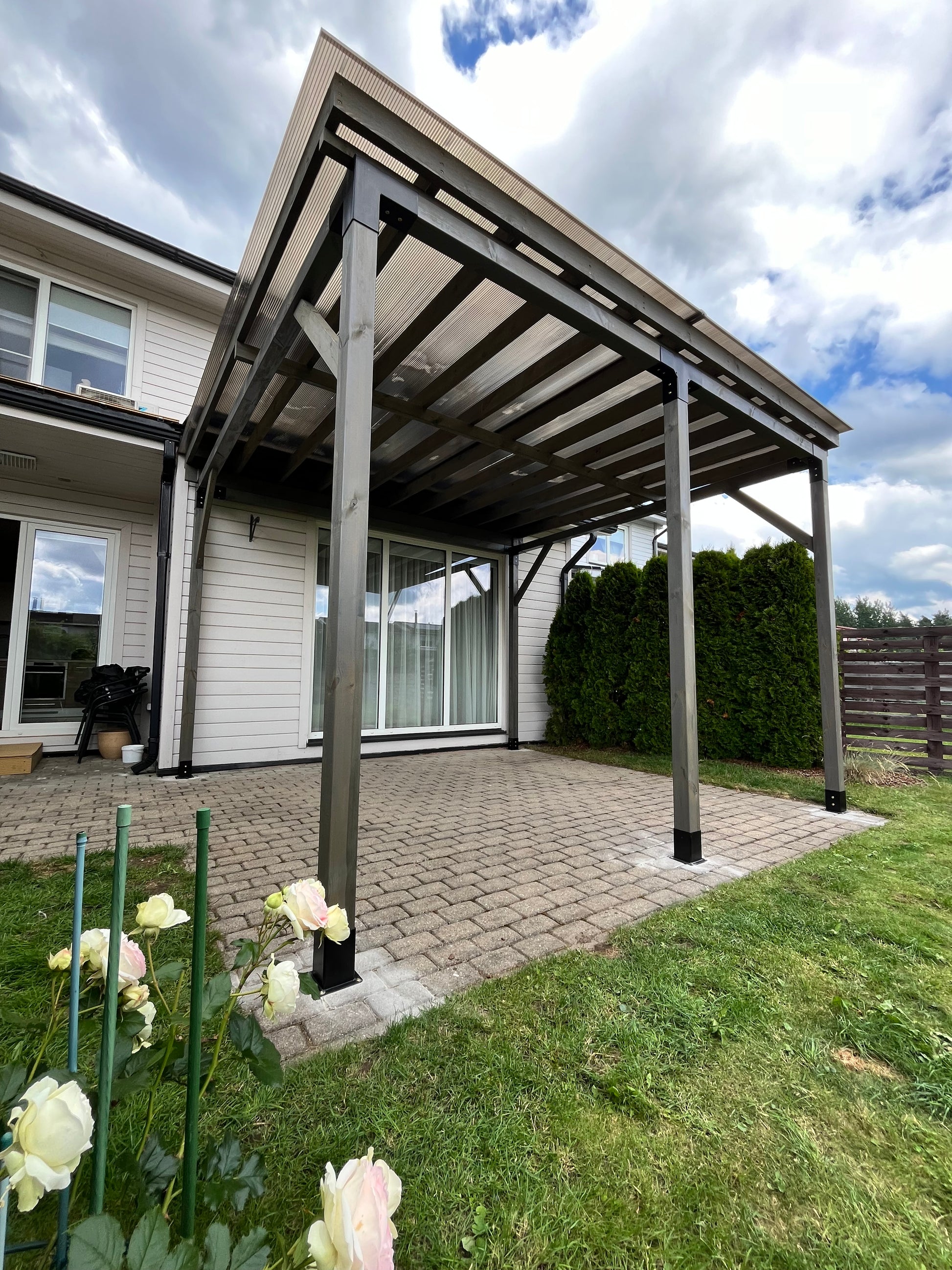 Outdoor patio table with chairs on a patio area with flowers in the foreground