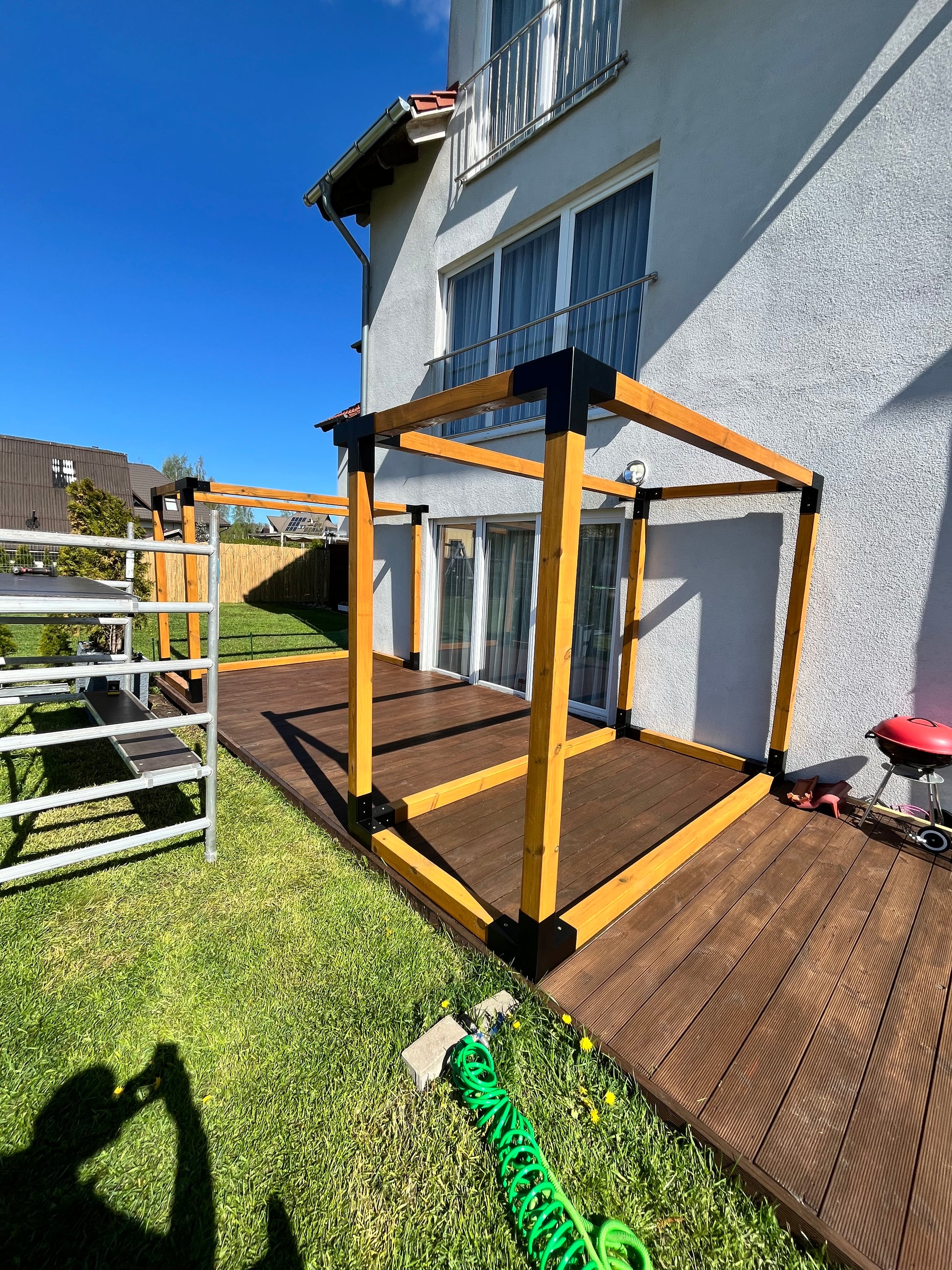 Wooden deck structure with a ladder on a grassy area