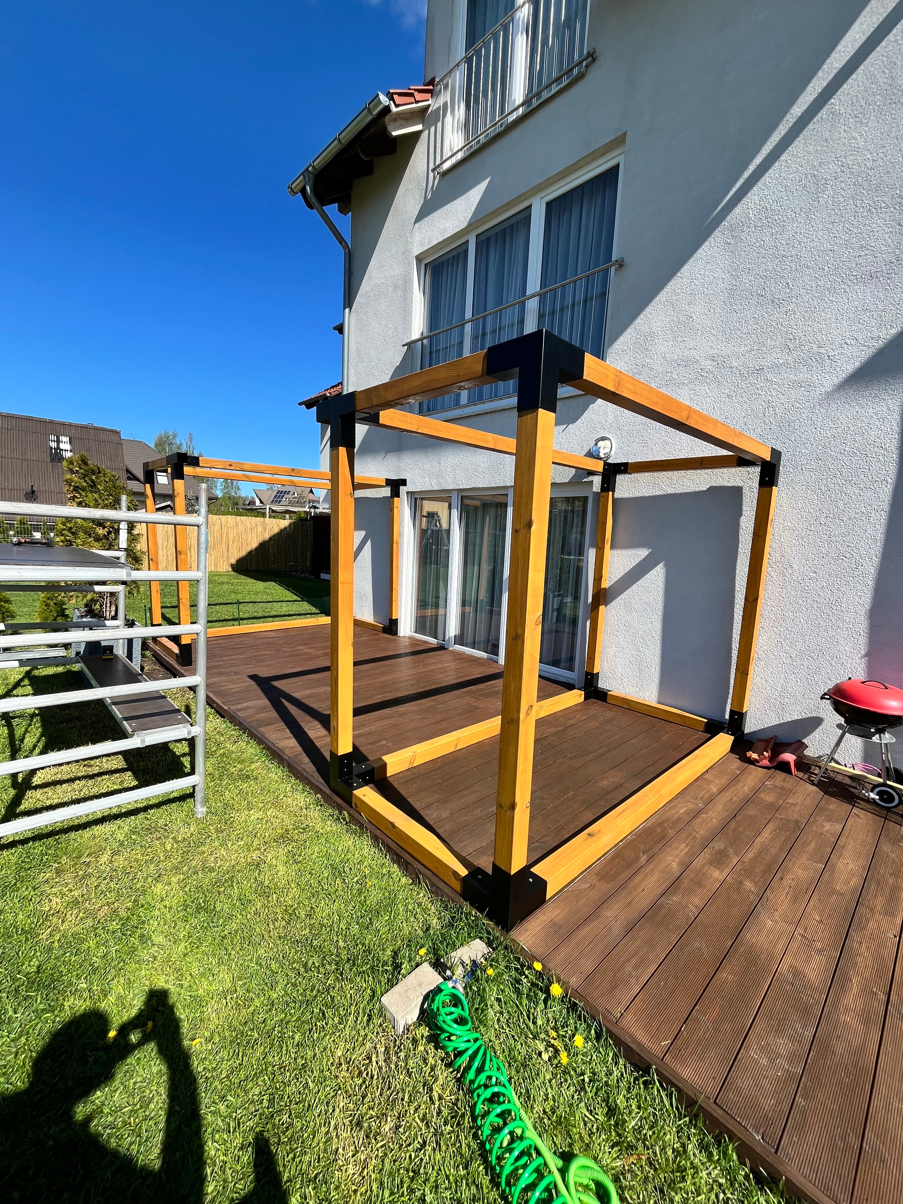 Wooden deck structure with a ladder on a grassy area