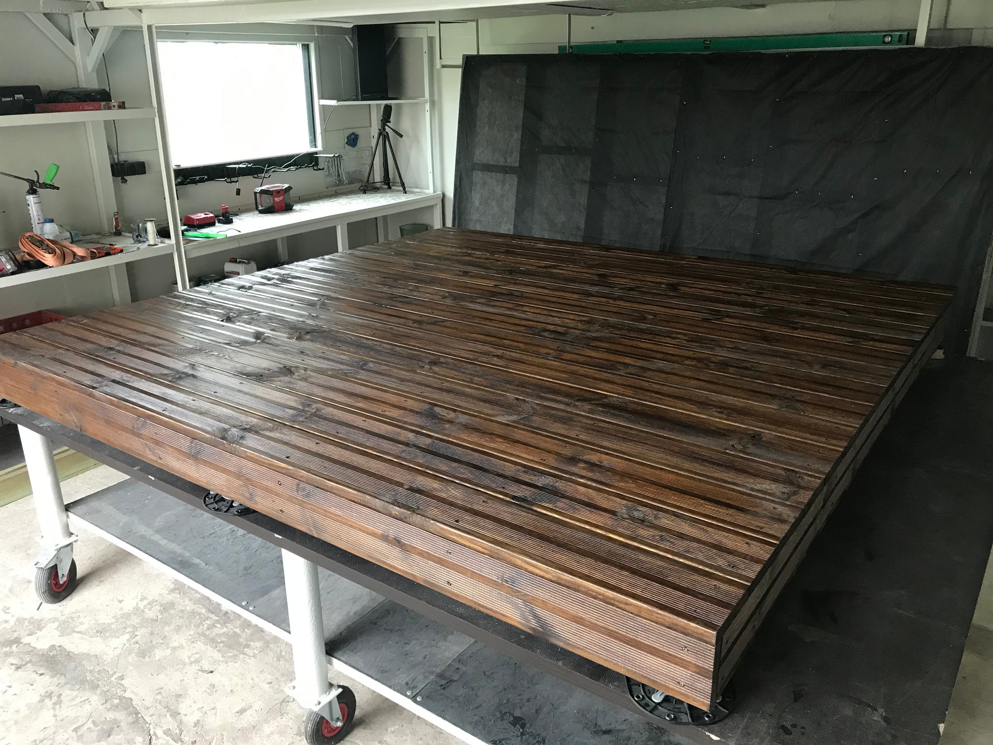 Wooden workbench with wheels in a workshop setting