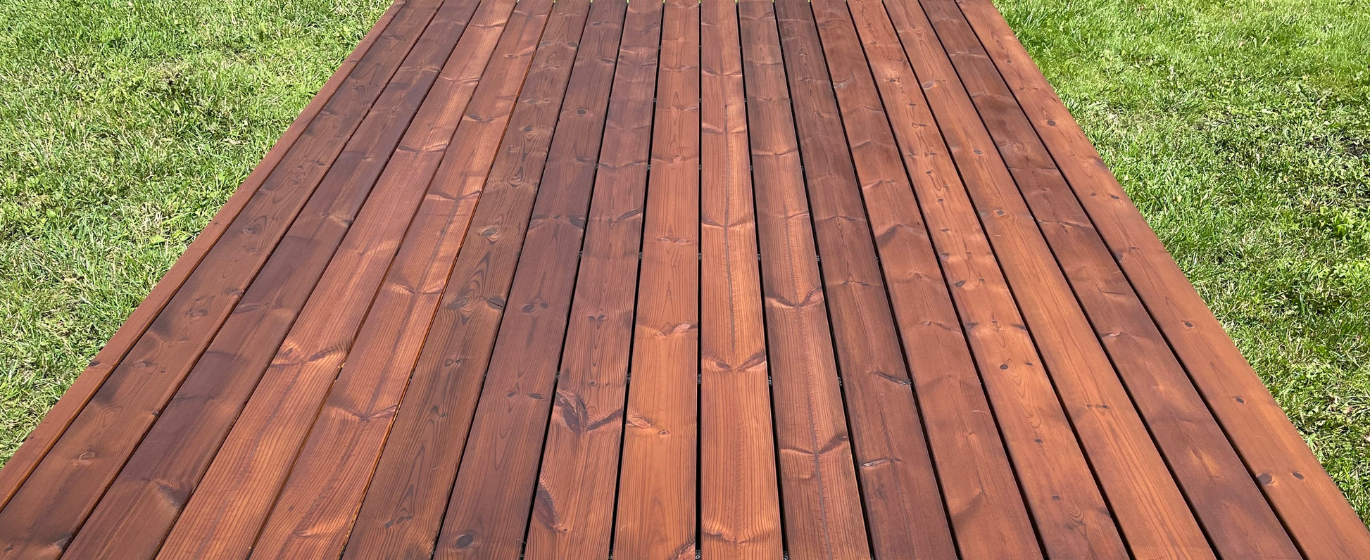 Wooden deck with a grassy background