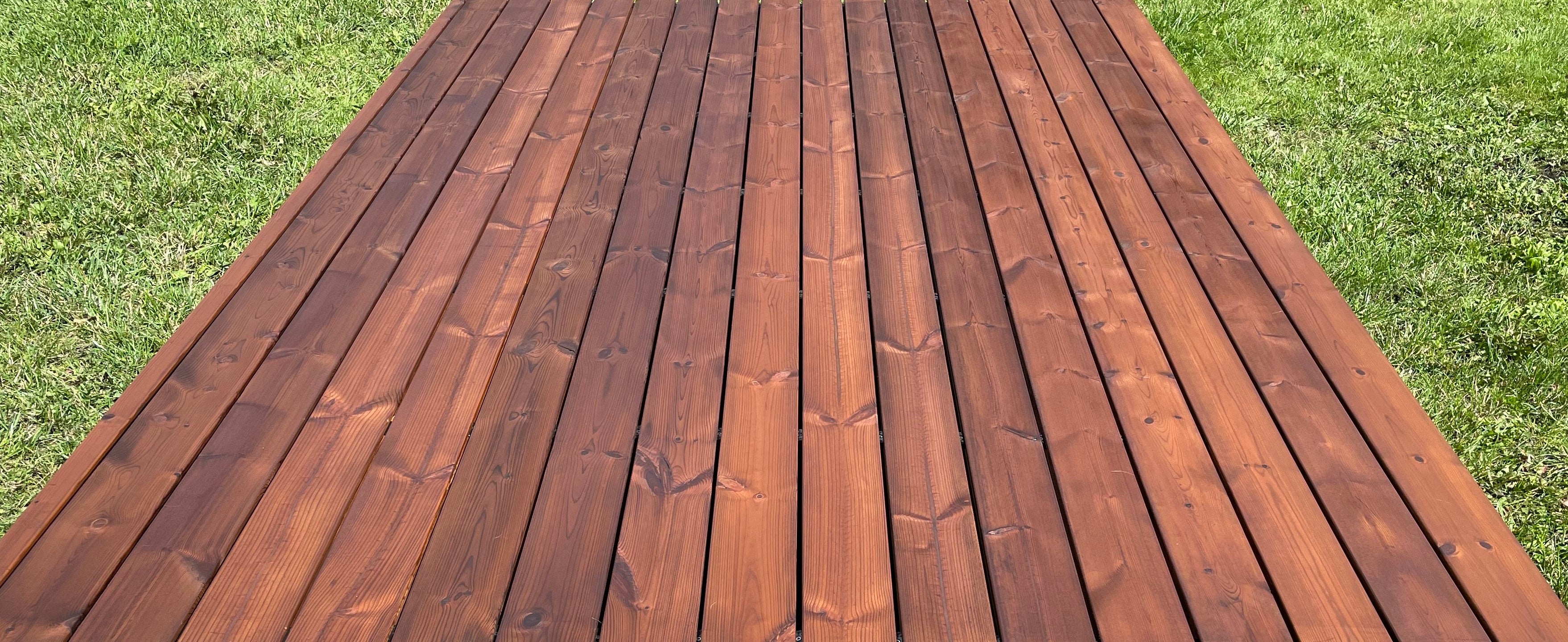 Wooden deck with a grassy background