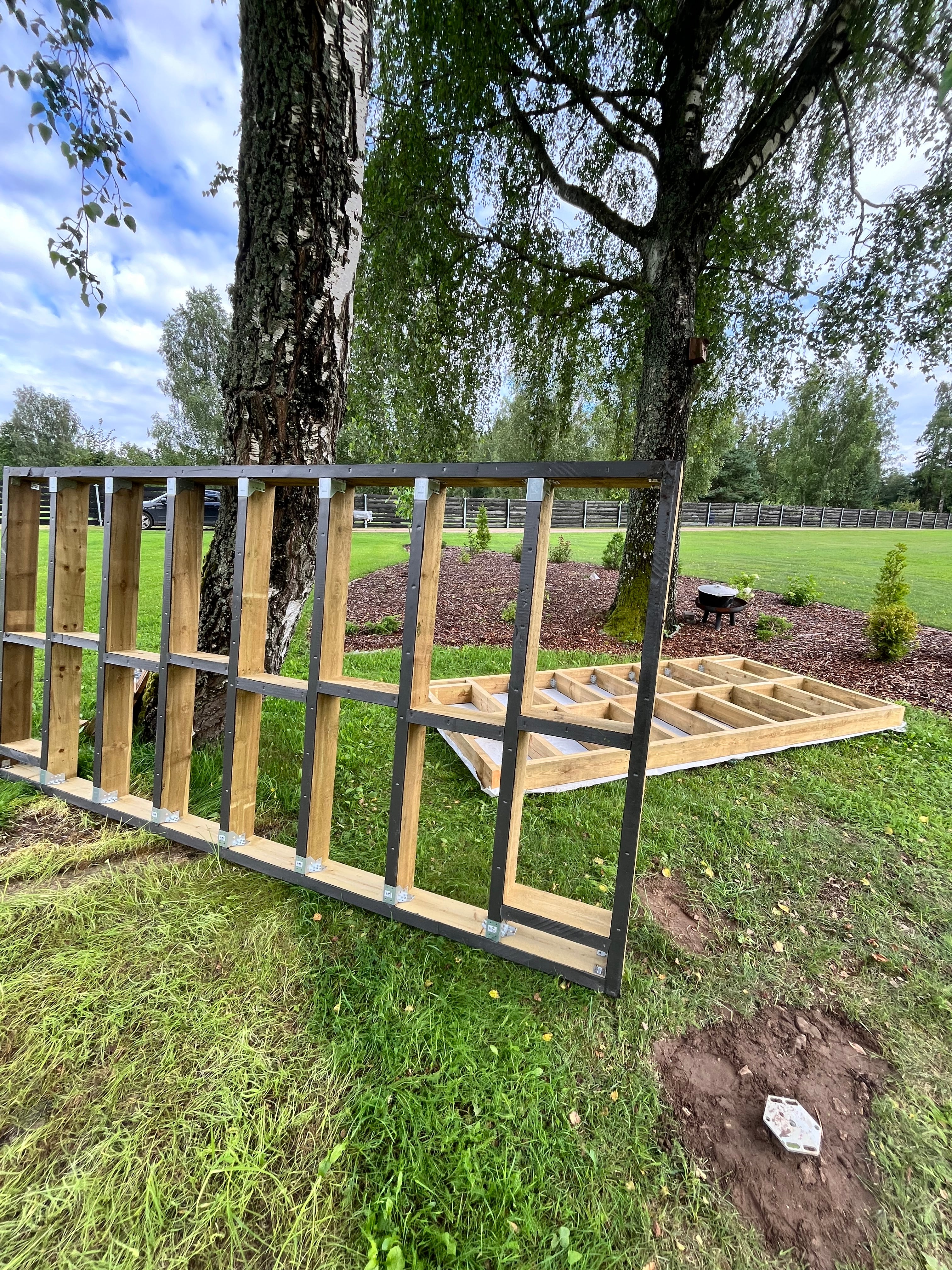 Wooden ladder leaning against a tree in a grassy area