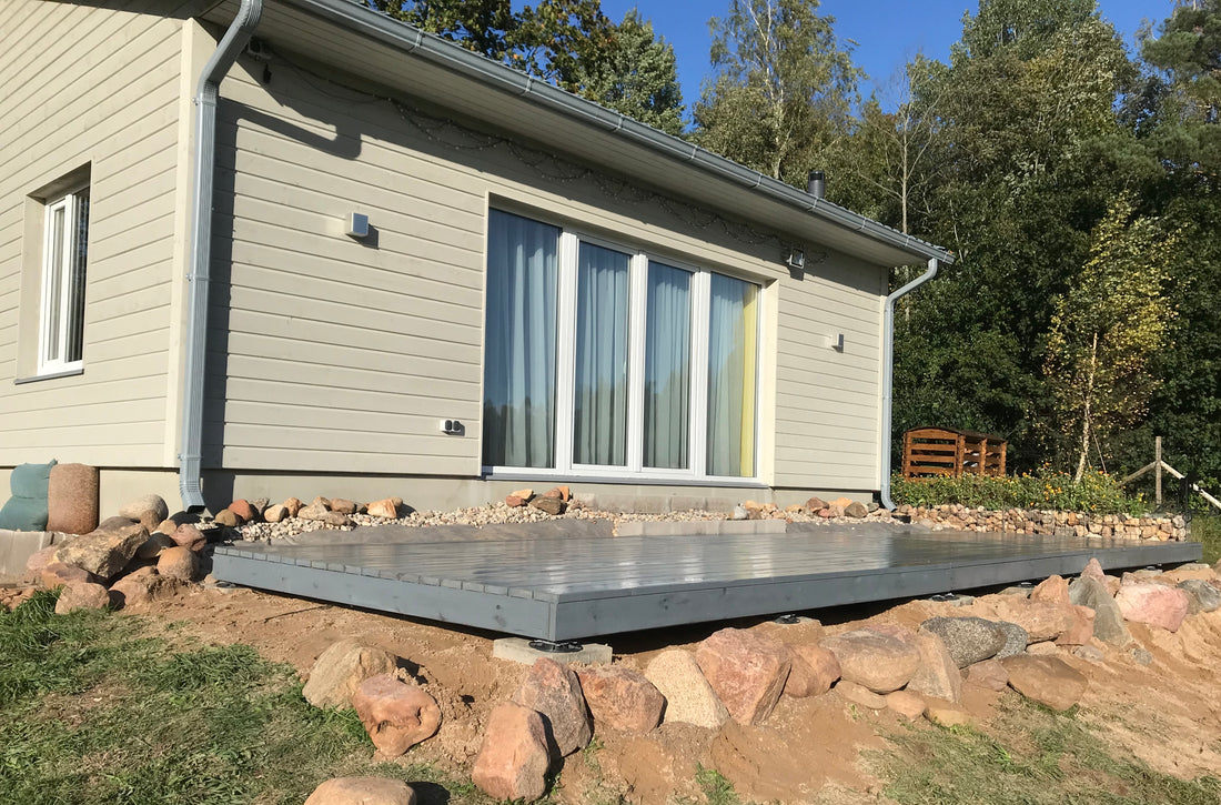 Modern house exterior with a stone patio and surrounding trees