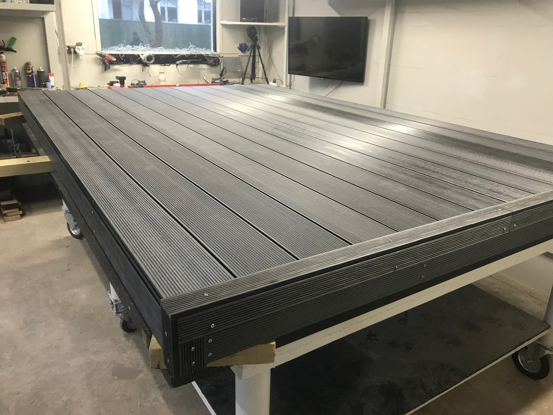 Gray wooden deck in front of a wooden house